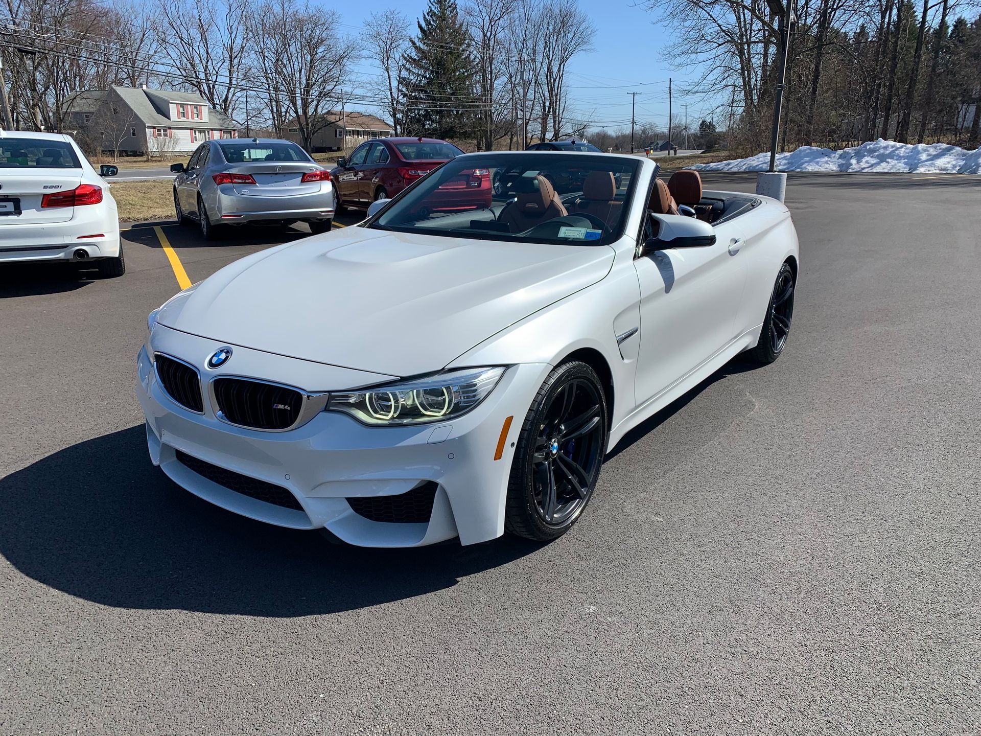 A white bmw m4 convertible is parked in a parking lot. | Lou's Car Care Center Inc.