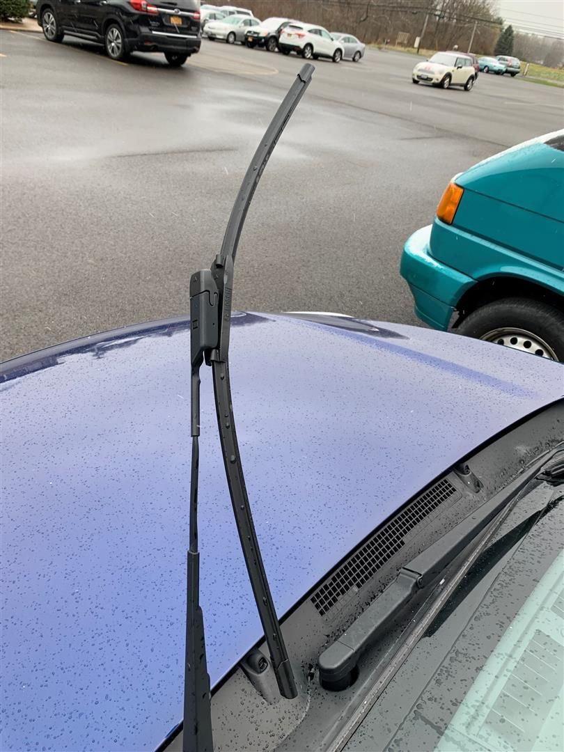 A close up of a windshield wiper on a blue car | Lou's Car Care Center Inc.