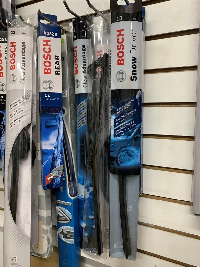 A row of bosch wiper blades hanging on a wall. | Lou's Car Care Center Inc.