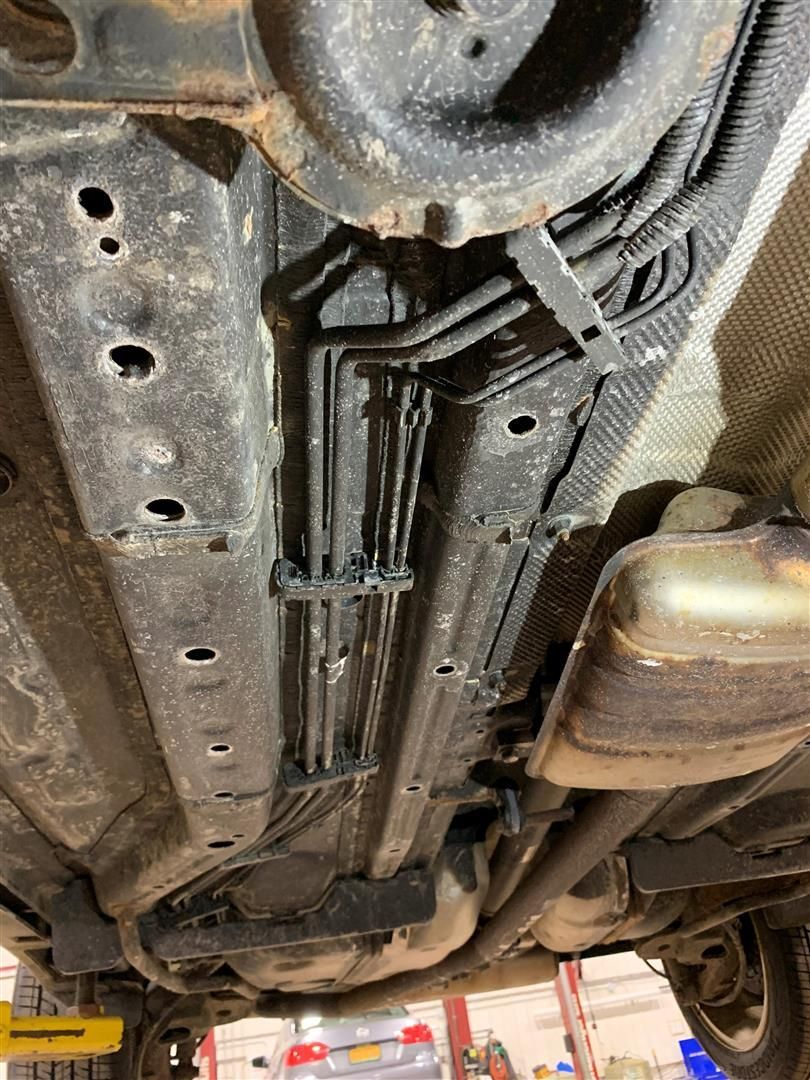 A close up of the underside of a car in a garage.  | Lou's Car Care Center Inc.