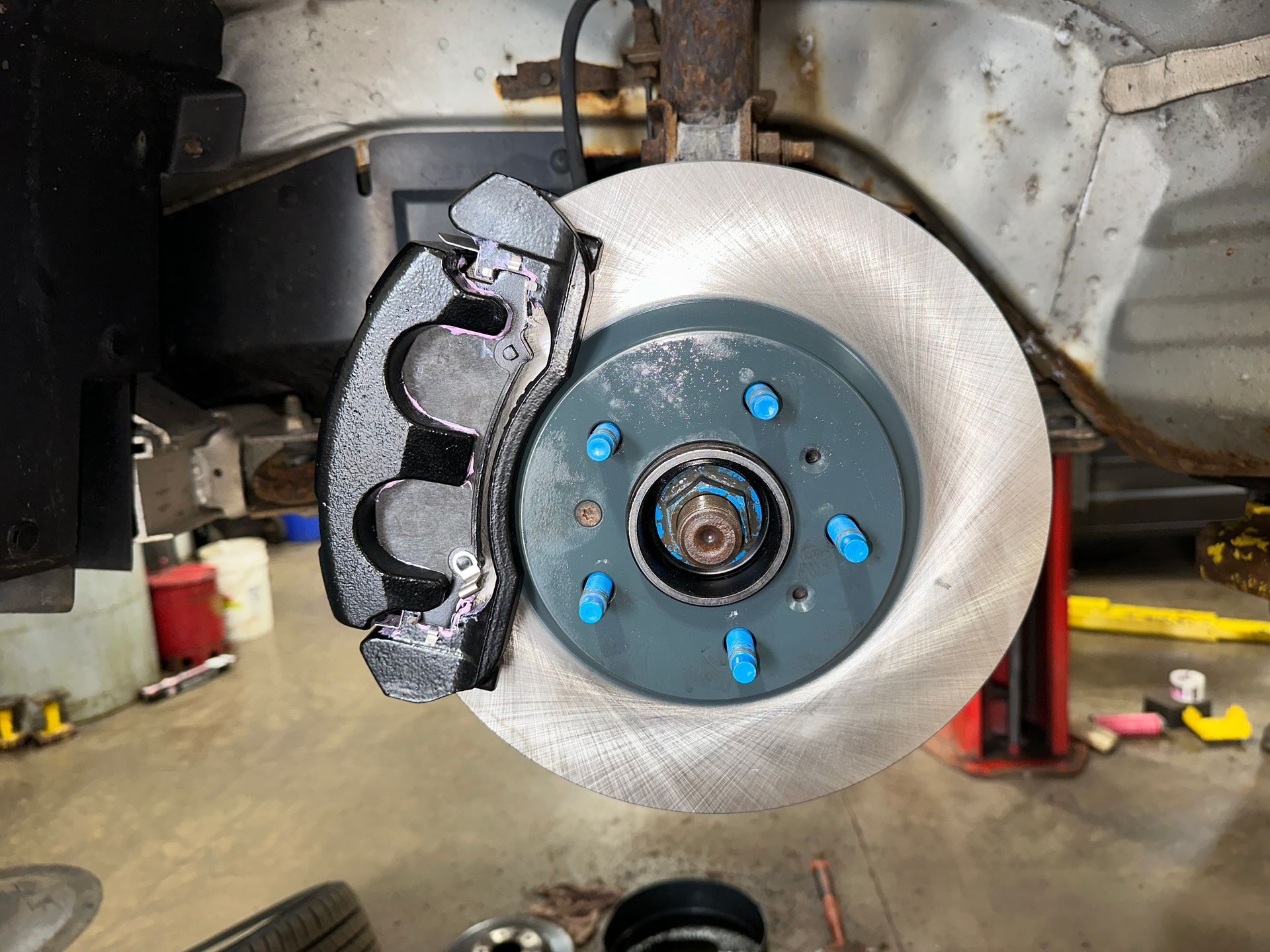 A close up of a brake disc on a car | Lou's Car Care Center Inc.