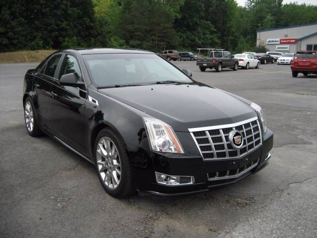 A black cadillac is parked in a parking lot | Lou's Car Care Center, Inc.