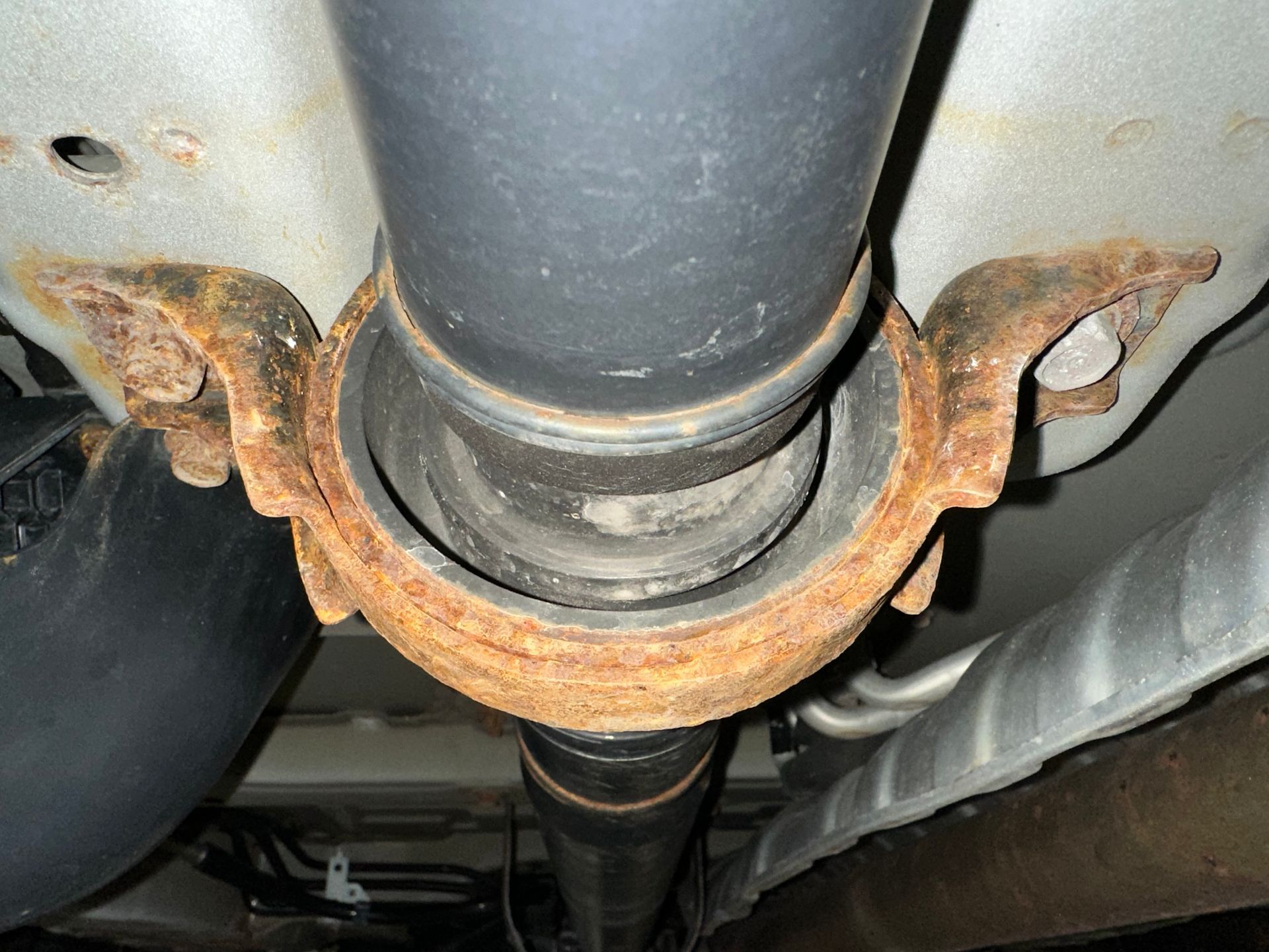 A close up of a rusty pipe under a car | Lou's Car Care Center, Inc.