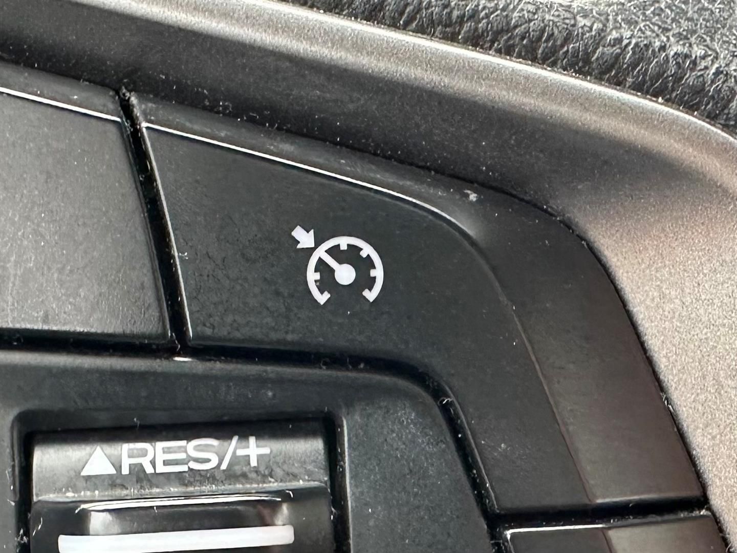 A close up of a car steering wheel with a clock on it. | Lou's Car Care Center Inc.