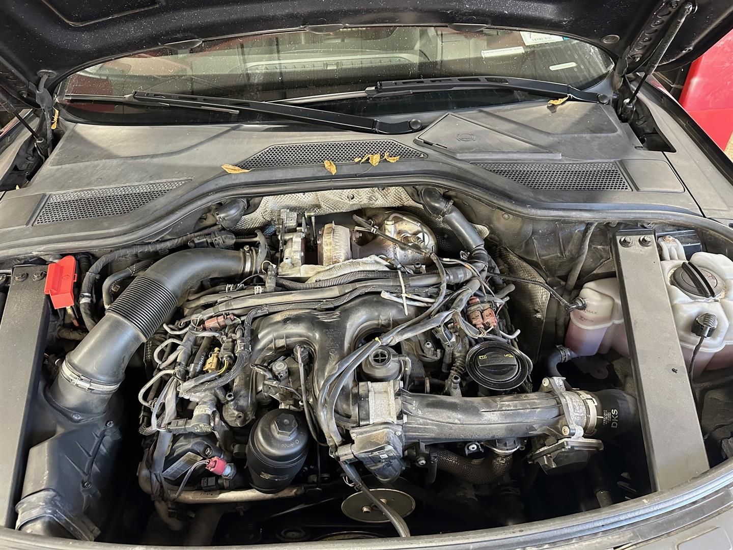 The engine of a car is shown with the hood open.  | Lou's Car Care Center, Inc.