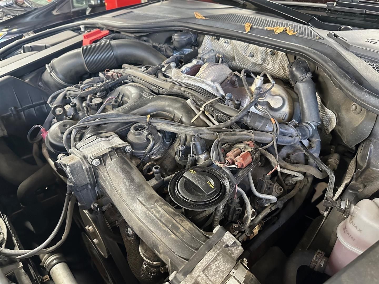 A close up of a car engine with a lot of wires coming out of it.  | Lou's Car Care Center, Inc.