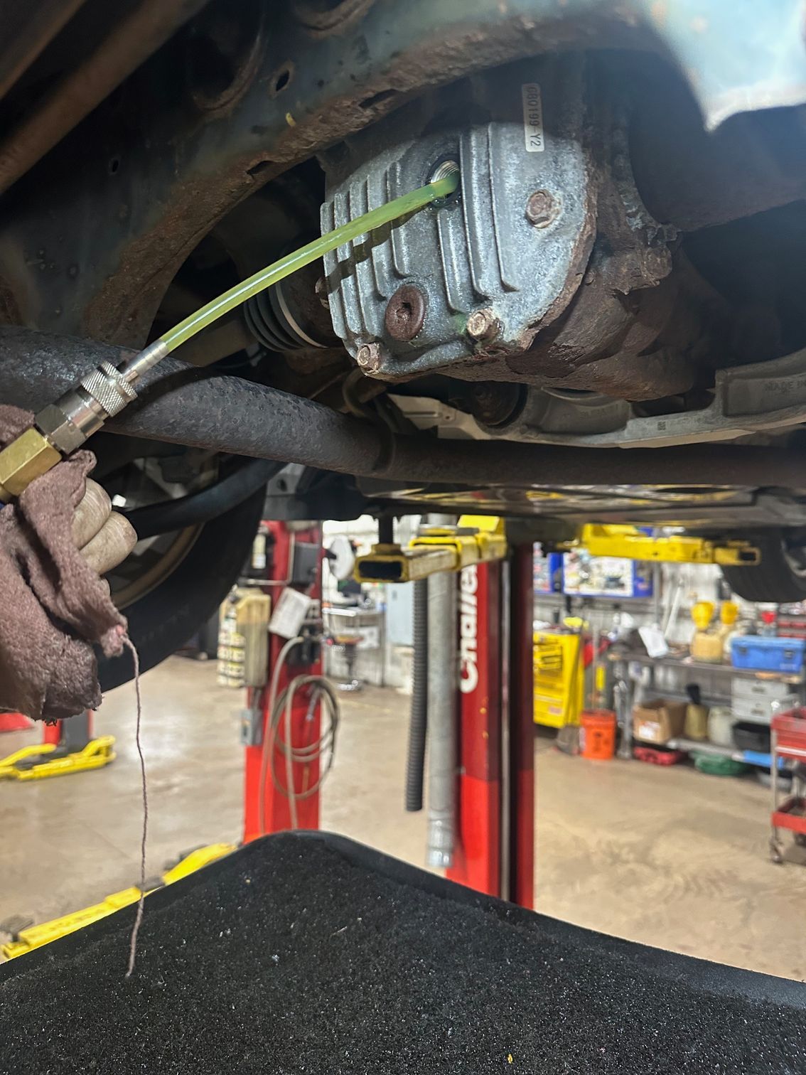 Differential pump hose adding gear oil to differential on a vehicle.