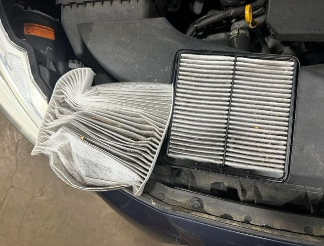 Dirty car filters on engine bay of vehicle waiting for replacement.