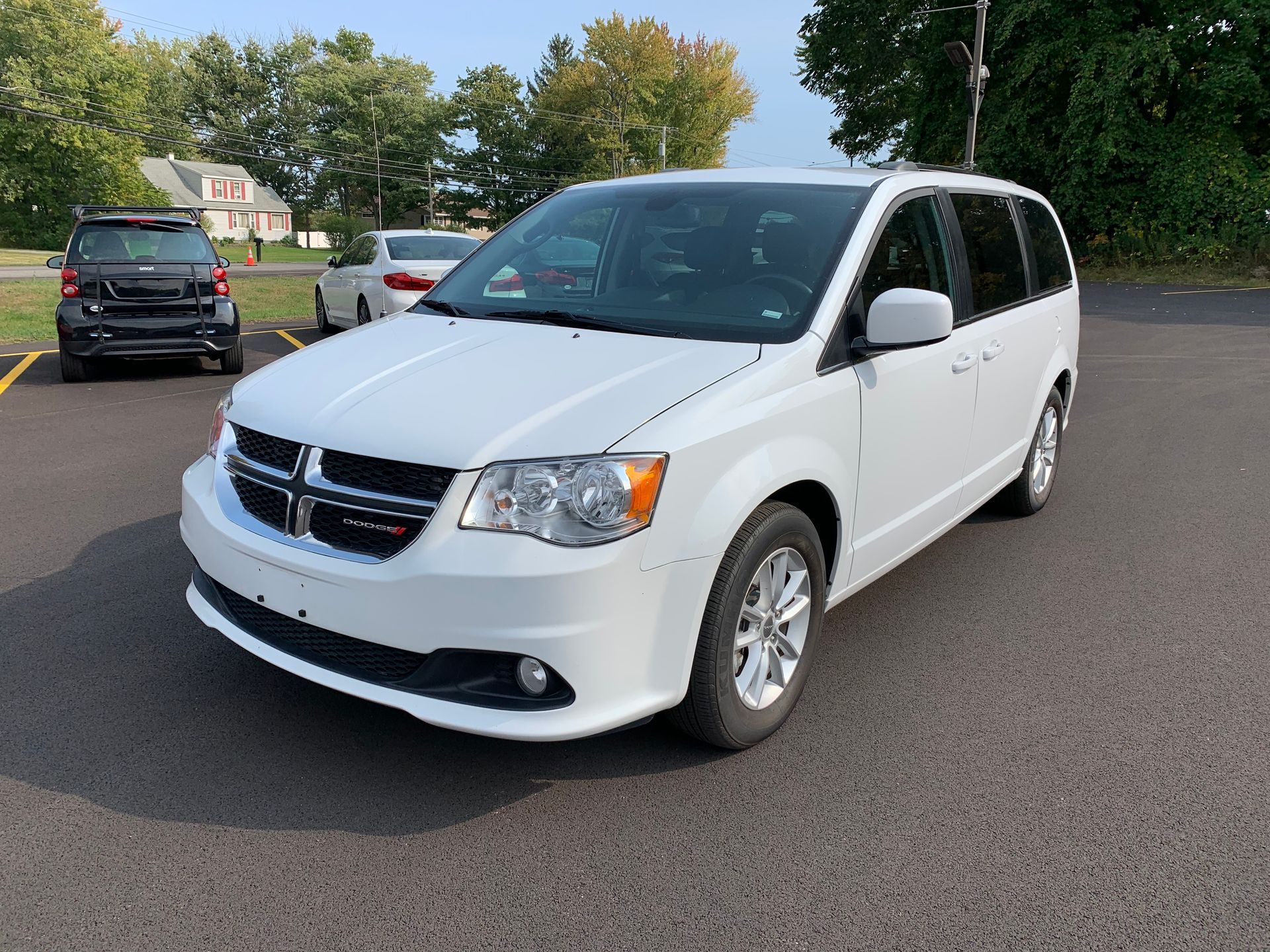 A white minivan is parked in a parking lot. | Lou's Car Care Center, Inc.