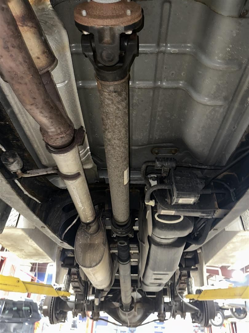 A close up of the underside of a car on a lift. | Lou's Car Care Center, Inc.