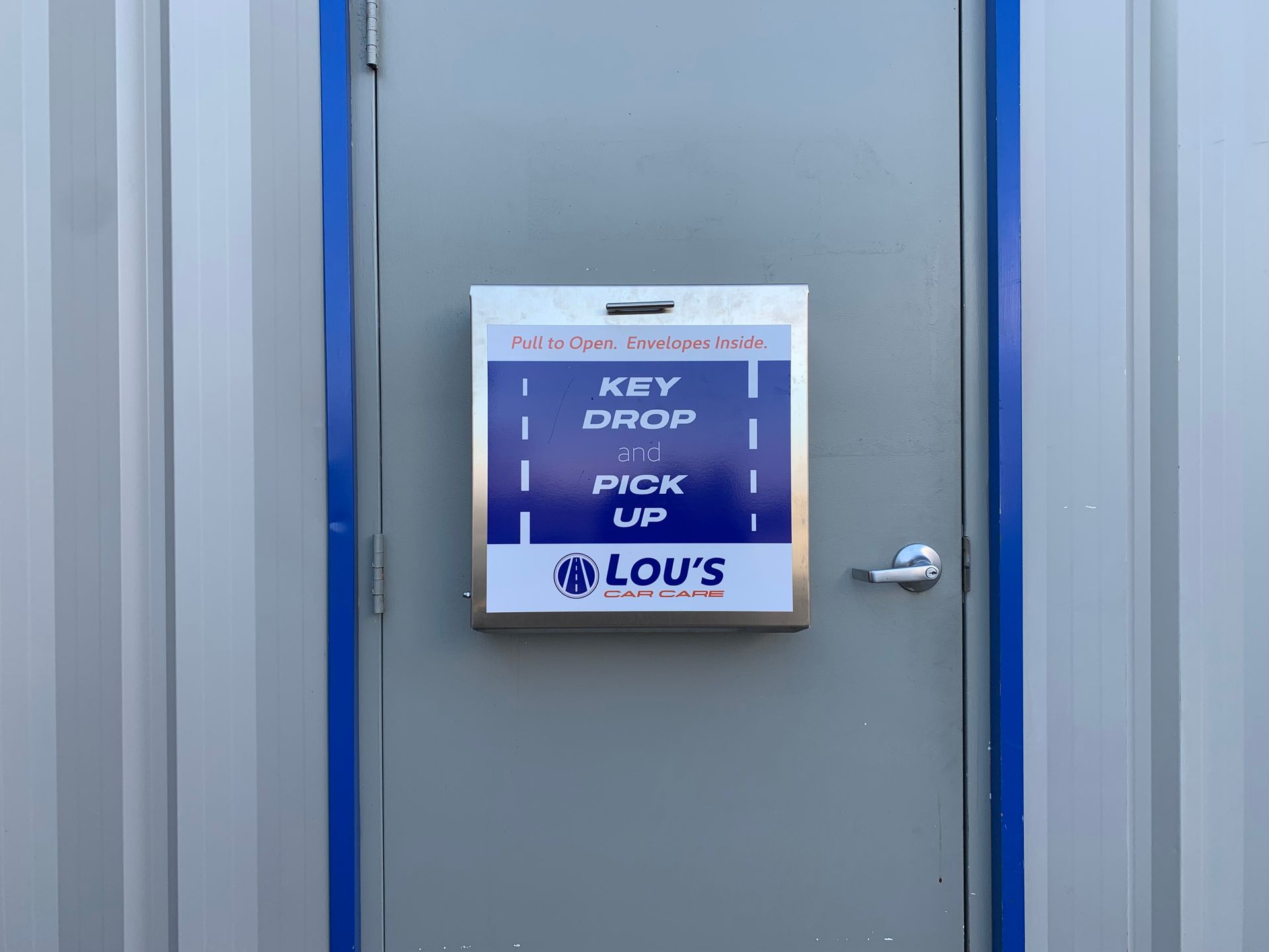 A door with a sign on it that says key drop pick up lou 's | Lou's Car Care Center Inc.