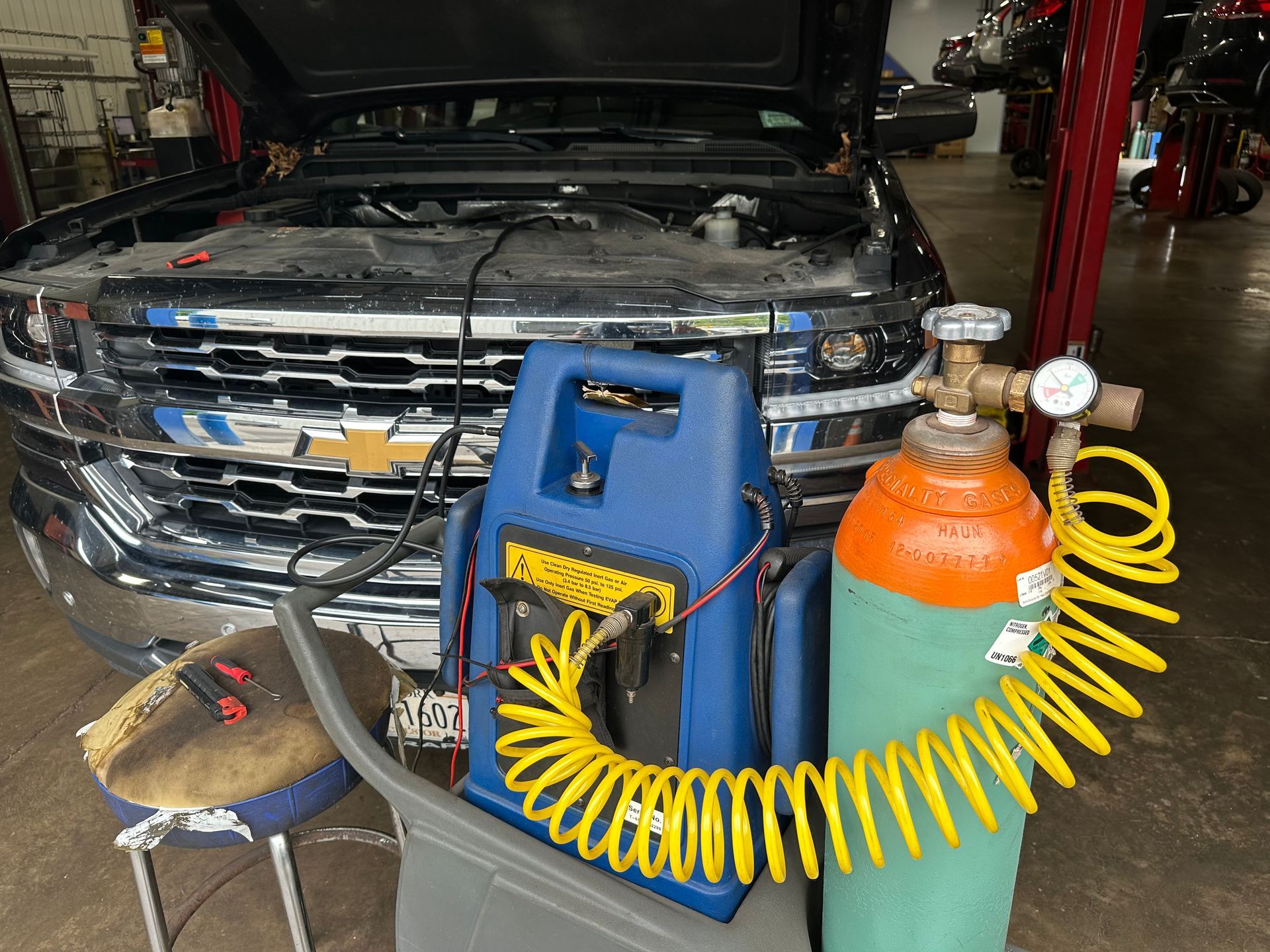 A truck is being serviced in a garage with the hood up.  | Lou's Car Care Center, Inc.