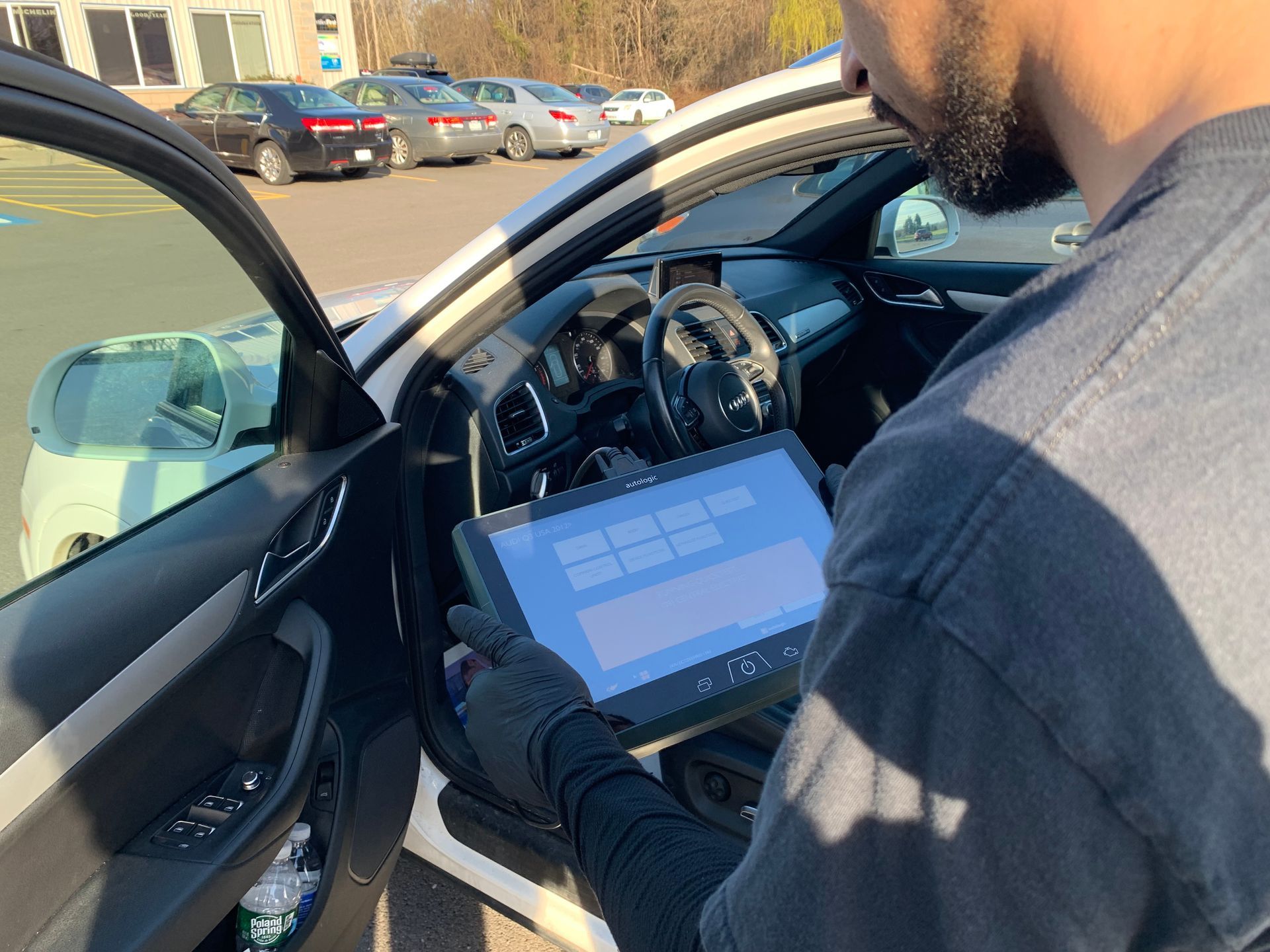 A man is using a tablet in a car.  | Lou's Car Care Center, Inc.