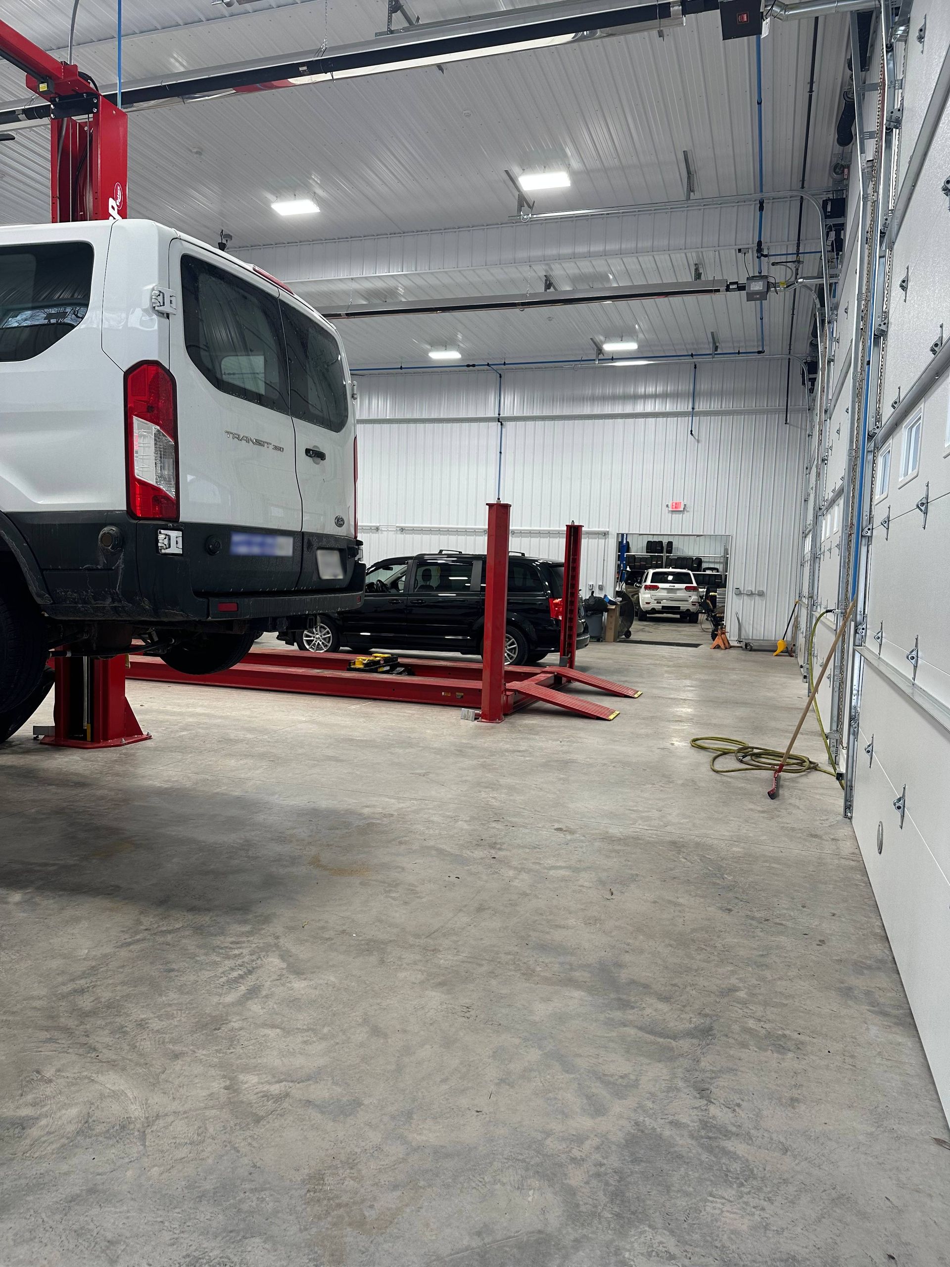 White van, black van, and white Jeep in Fleet Center. | Lou's Car Care Center, Inc.