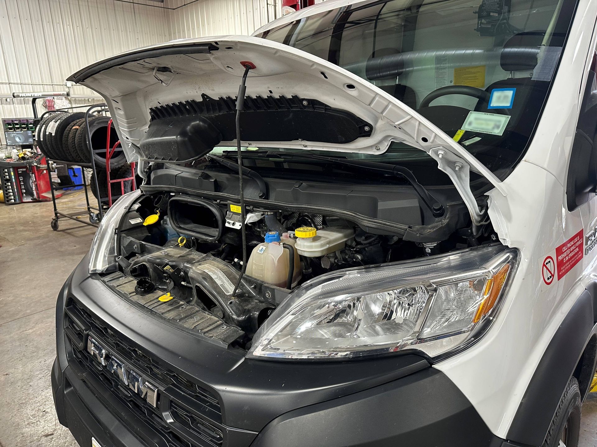 White fleet vehicle with hood open in the shop.