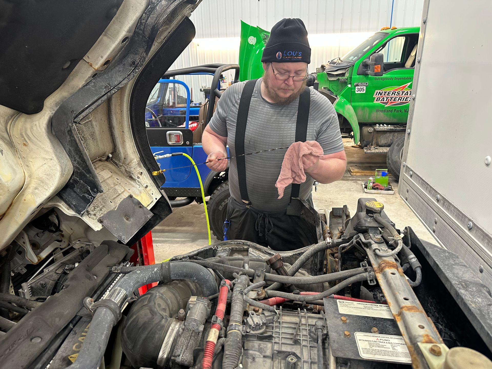 Auto technician check fluid levels on a fleet truck in shop. | Lou's Car Care Center, Inc.