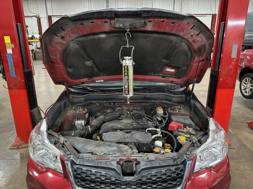Fluid Flush Service on red vehicle in shop | Lou's Car Care Center, Inc.