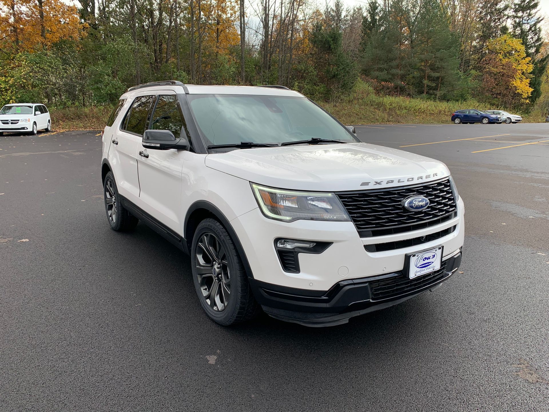 A white ford explorer is parked in a parking lot. | Lou's Car Care Center, Inc.