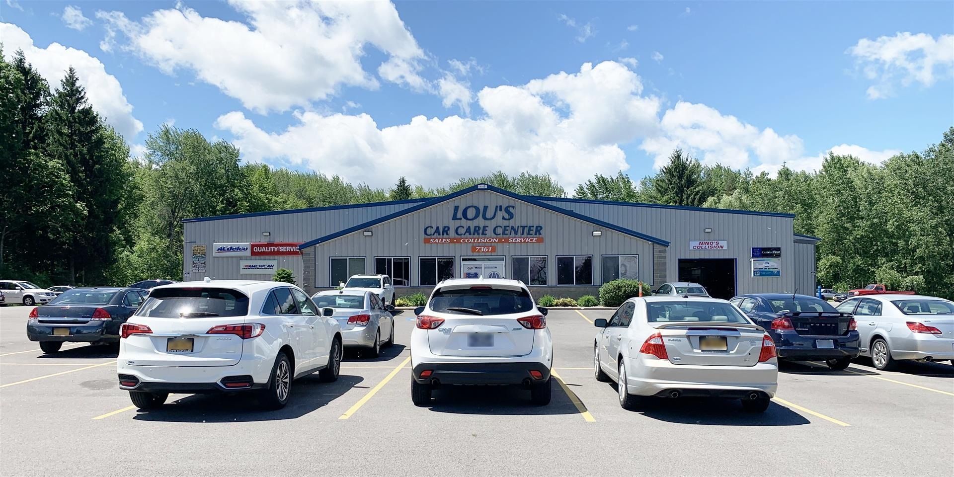 A lot of cars are parked in front of a building. | Lou's Car Care Center