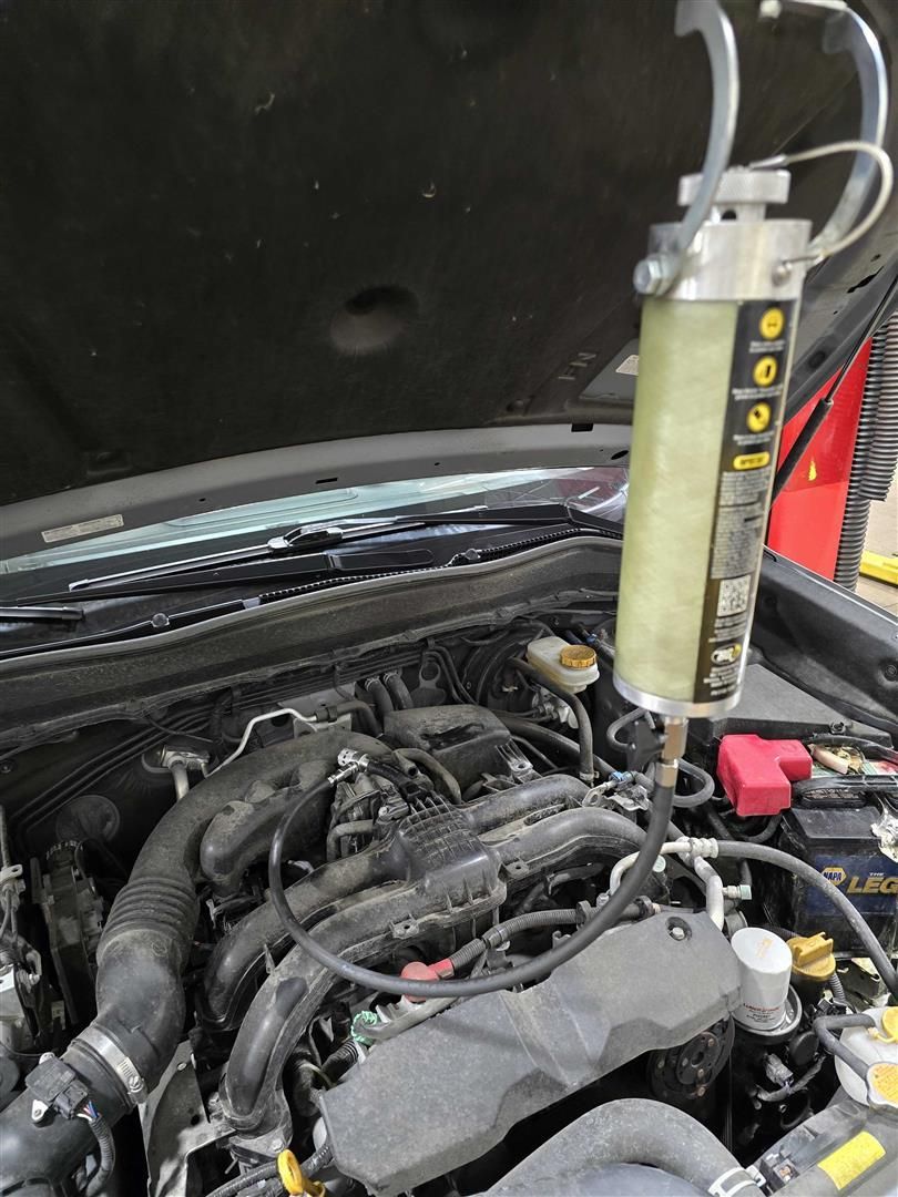 A close up of a car engine with the hood open  | Lou's Car Care Center, Inc.