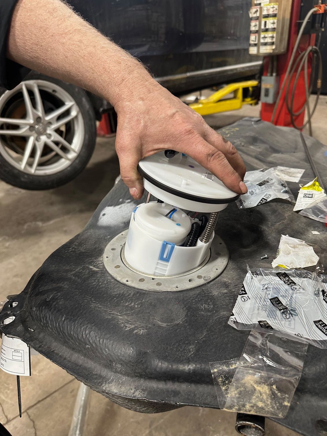 New, white fuel pump being inserted into new, black gas tank | Lou's Car Care Center, Inc.