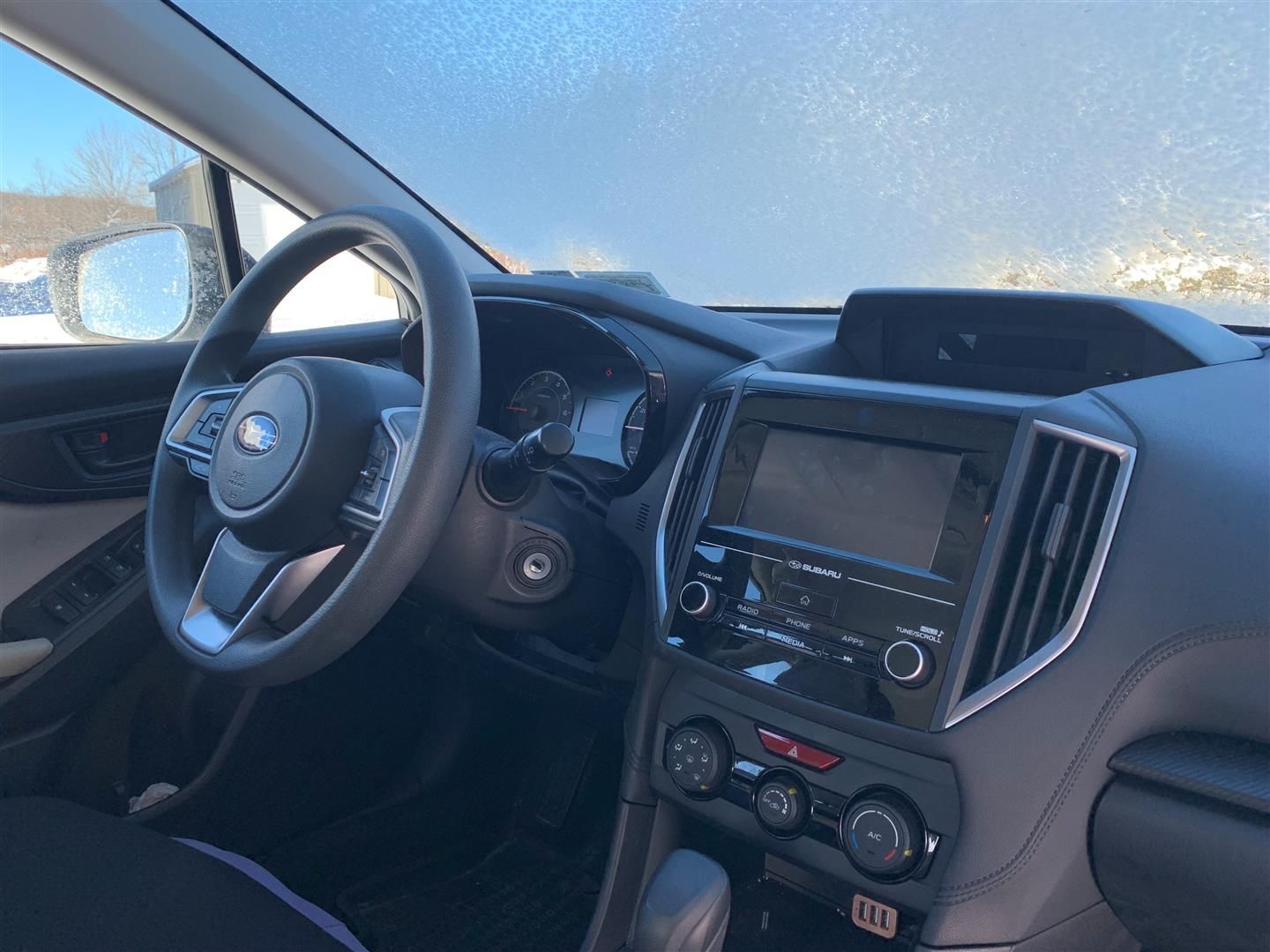 The interior of a car with a steering wheel and a radio. | Lou's Car Care Center Inc.