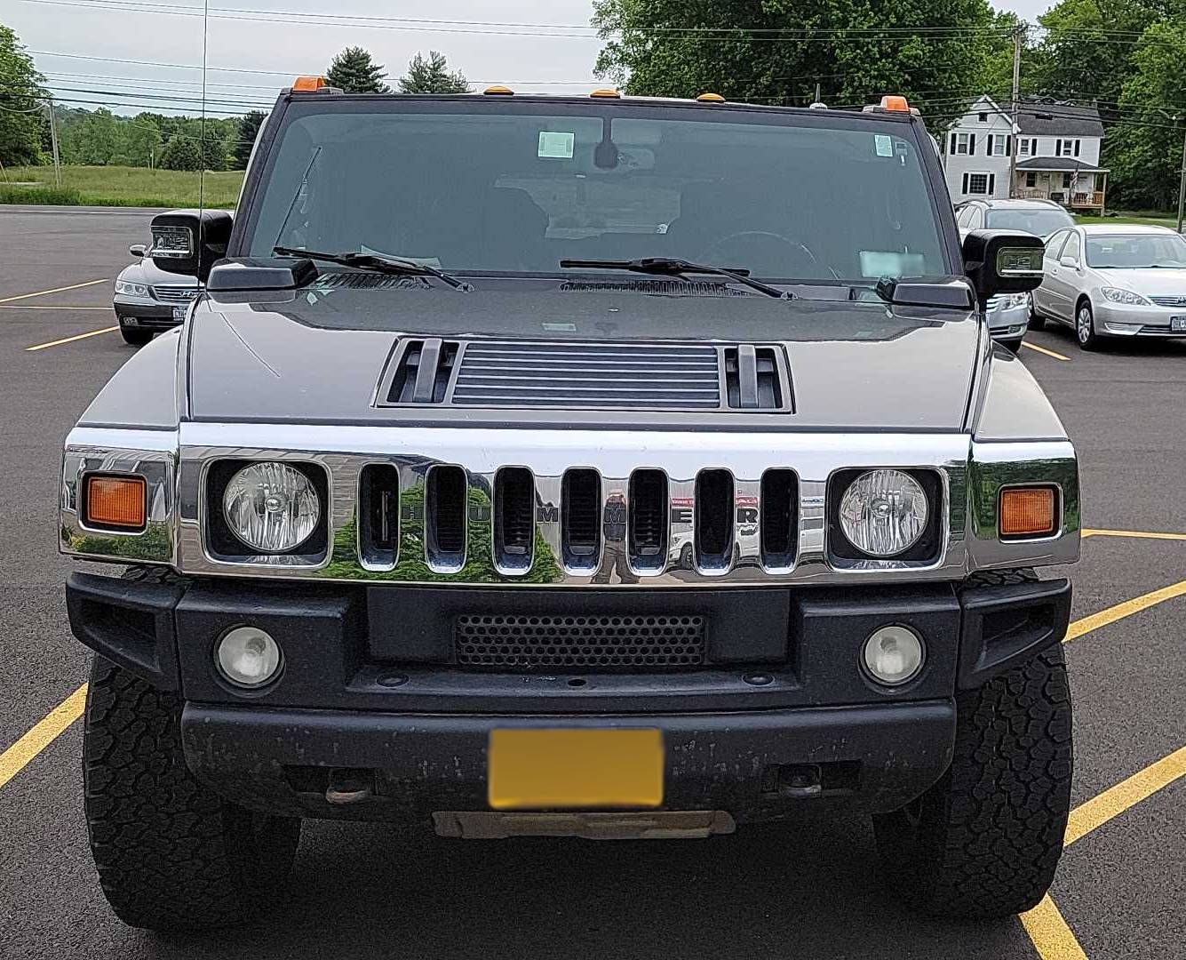 A hummer is parked in a parking lot with other cars | Lou's Car Care Center, Inc.