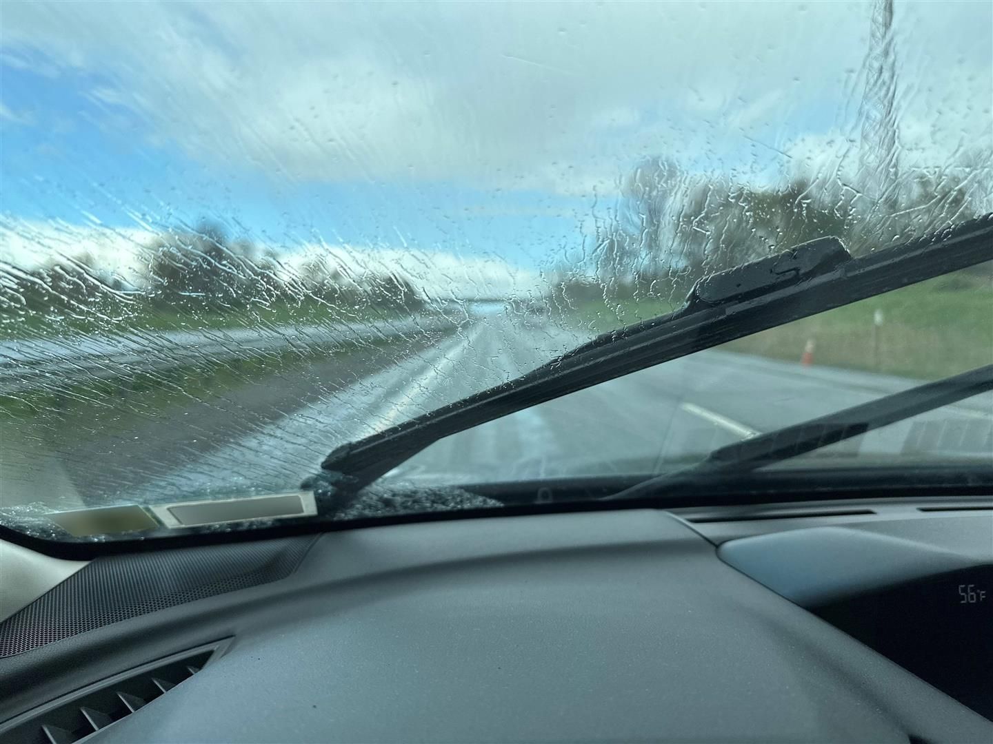 A car windshield with a wiper blade on it. | Lou's Car Care Center Inc.