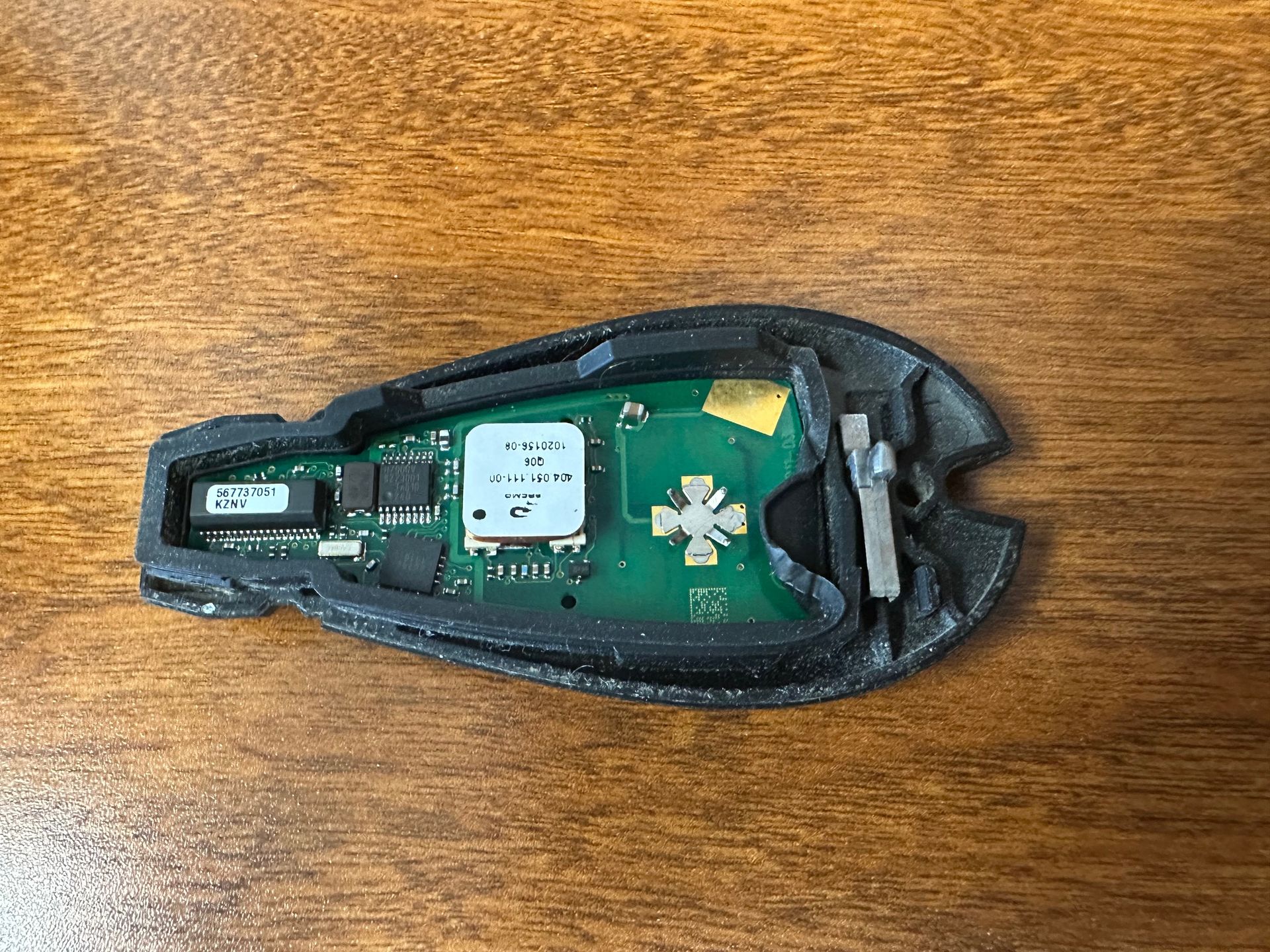 Jeep key fob circuit board on wooden desk.