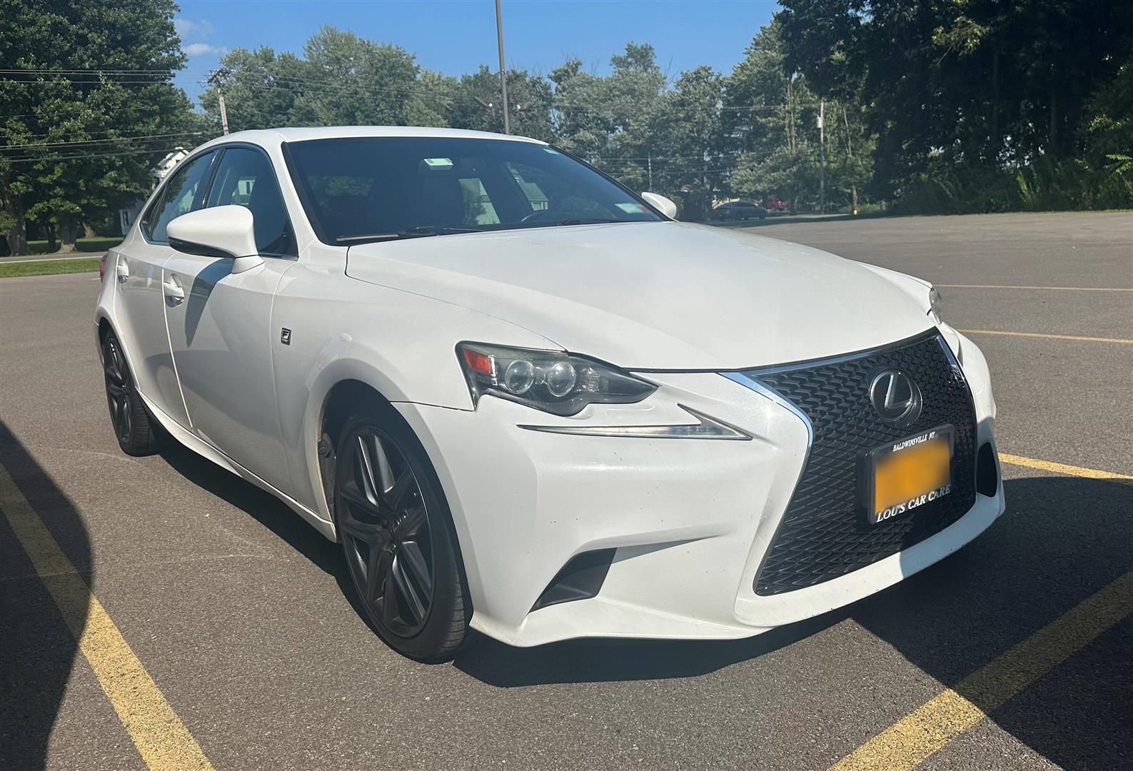 A white lexus is parked in a parking lot. | Lou's Car Care Center, Inc.