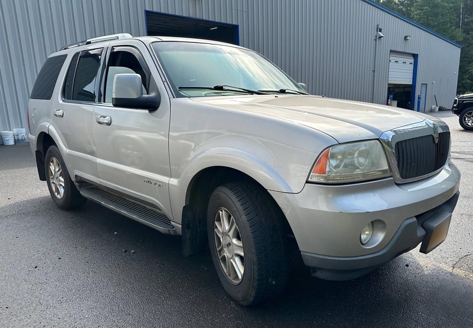 A silver ford expedition is parked in front of a building. | Lou's Car Care Center, Inc.