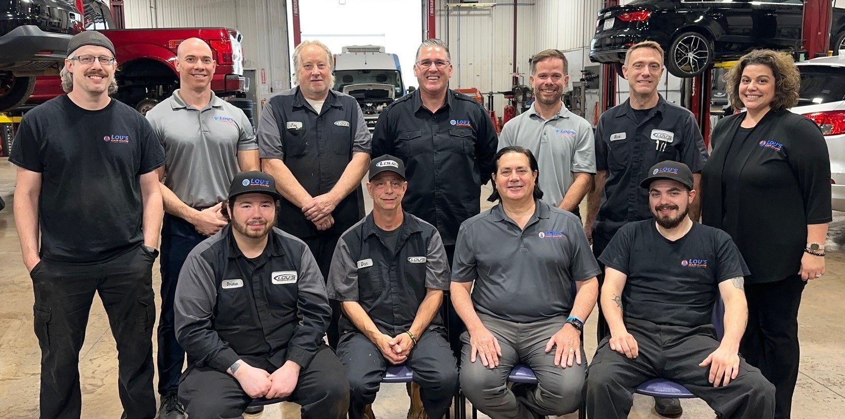 A group of people are posing for a picture in a garage. | Lou's Car Care Center