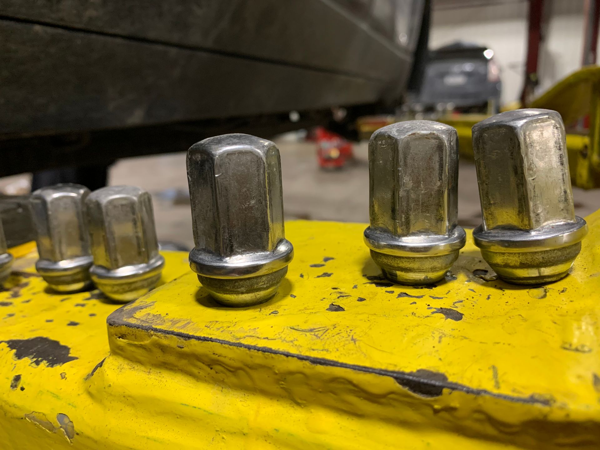 A bunch of nuts are sitting on top of a yellow table. | Lou's Car Care Center, Inc.