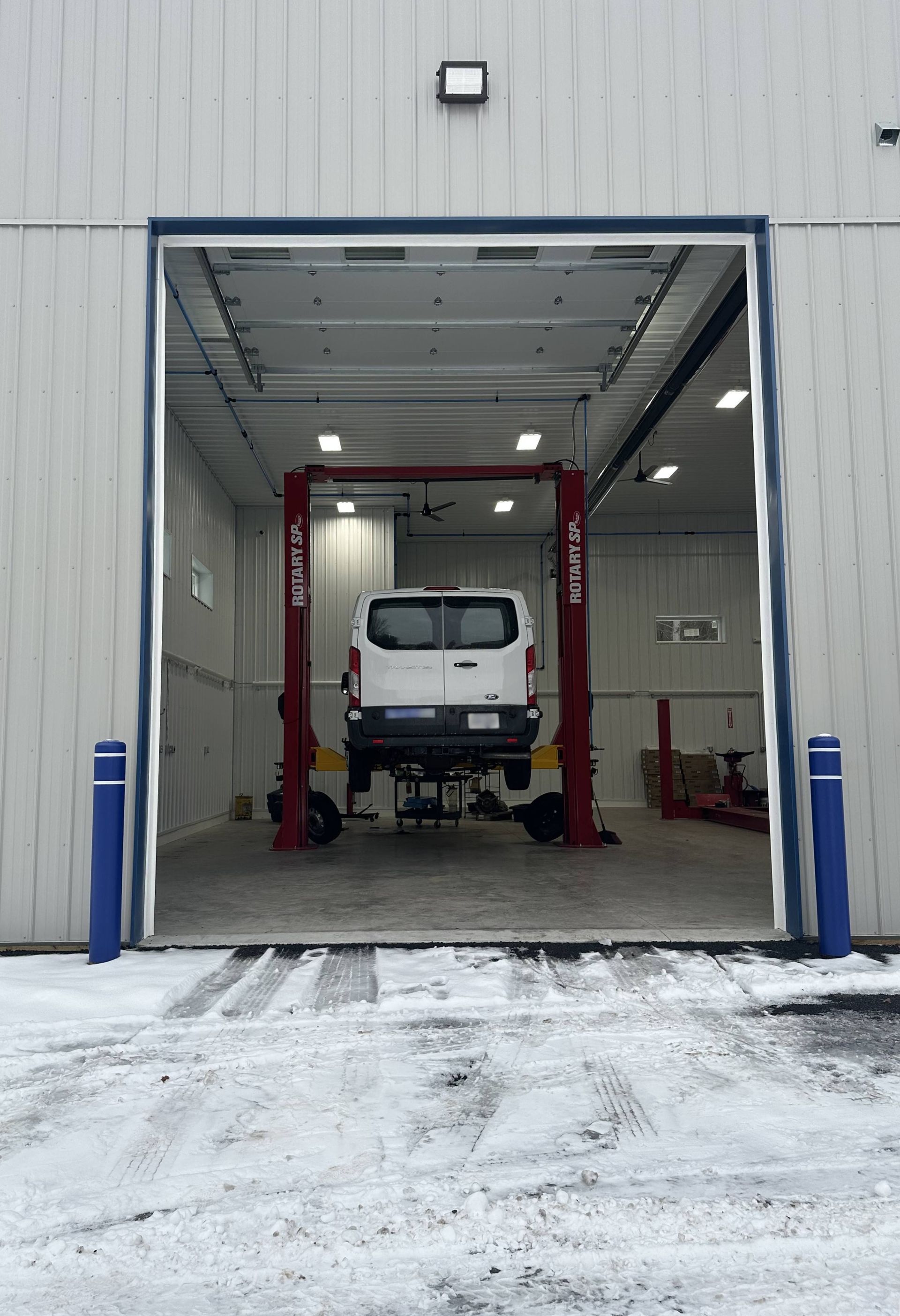 White Ford van on medium duty rotary lift in new fleet center. | Lou's Car Care Center, Inc.