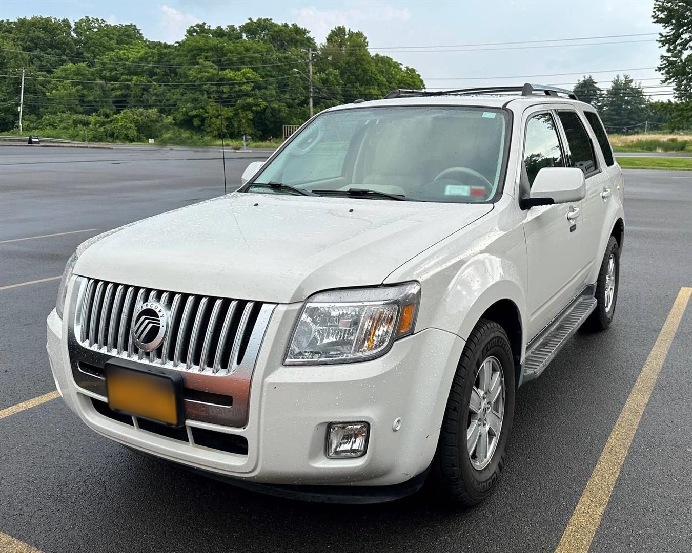 A white mercury mountaineer is parked in a parking lot | Lou's Car Care Center, Inc.