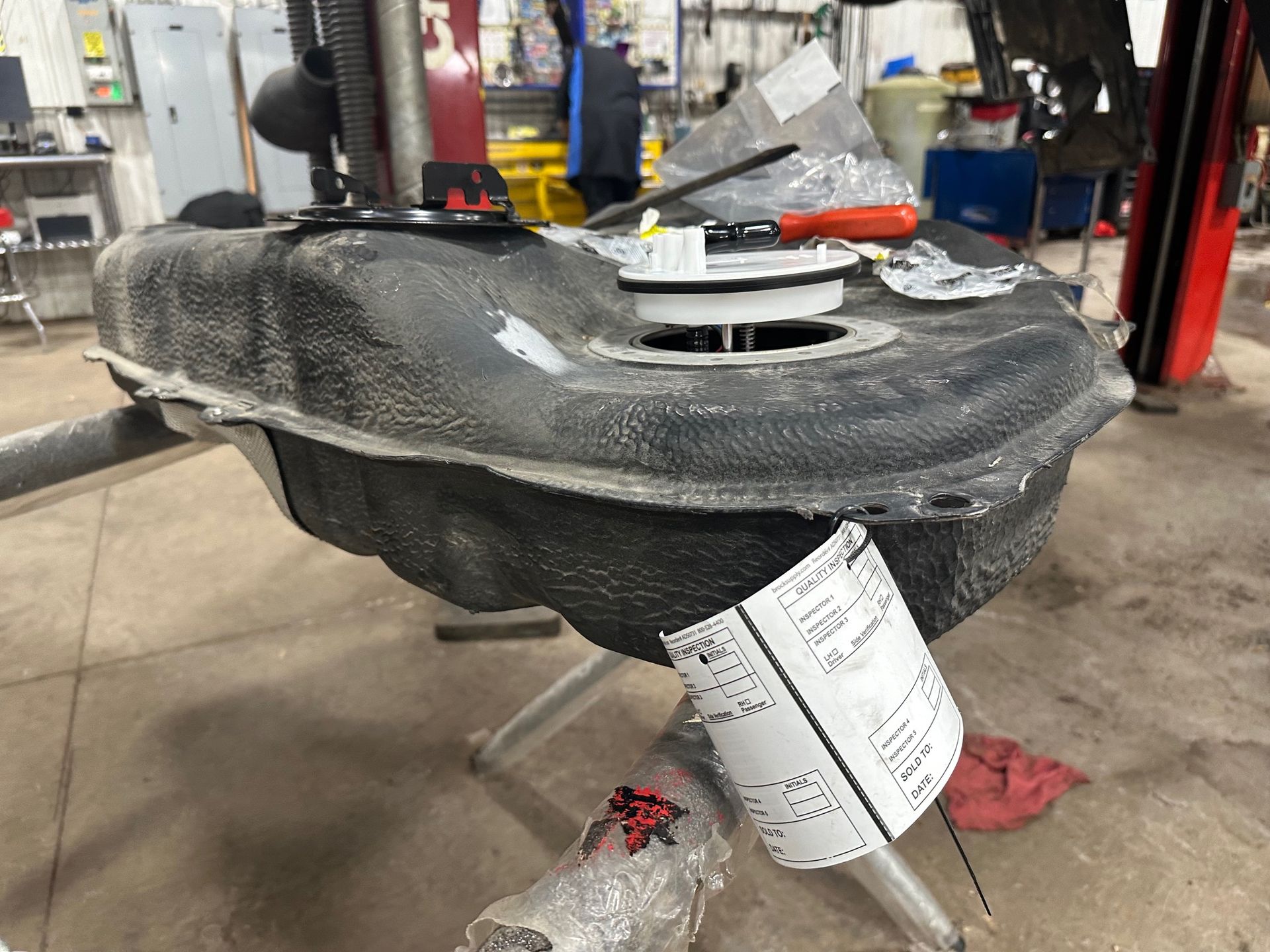 New fuel pump and black gas tank on stand in mechanic shop | Lou's Car Care Center, Inc.