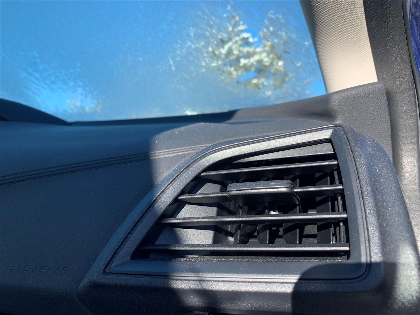 A close up of a car air vent with a blue sky in the background. | Lou's Car Care Center Inc.