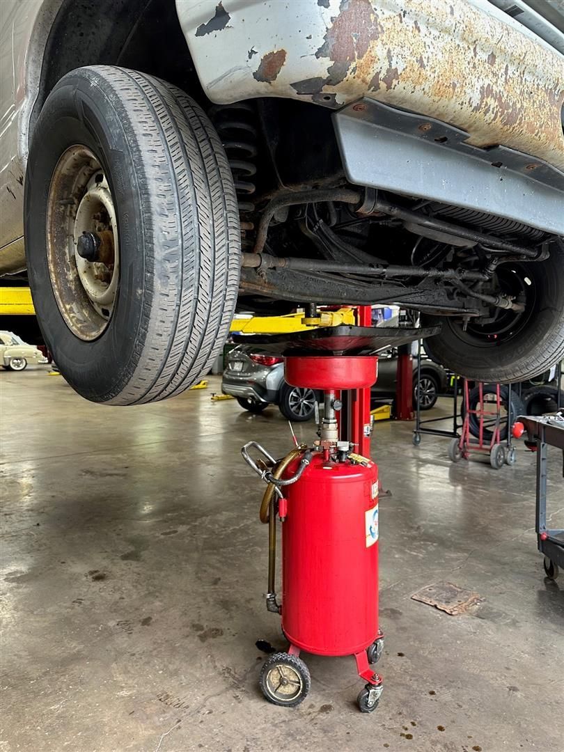 A car is sitting on a lift in a garage. | Lou's Car Care Center, Inc.