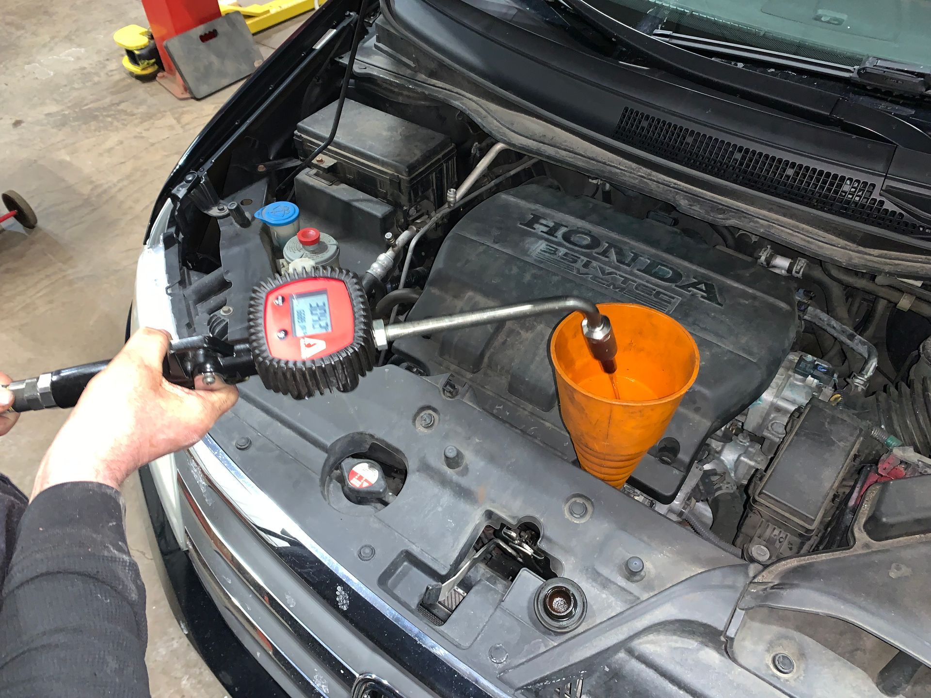 A person is working on the engine of a honda car. | Lou's Car Care Center, Inc.