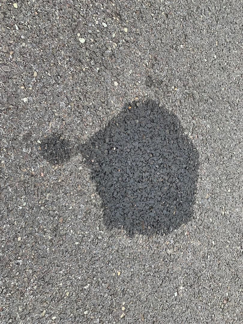 A close up of a puddle of oil on the ground. | Lou's Car Care Center, Inc.