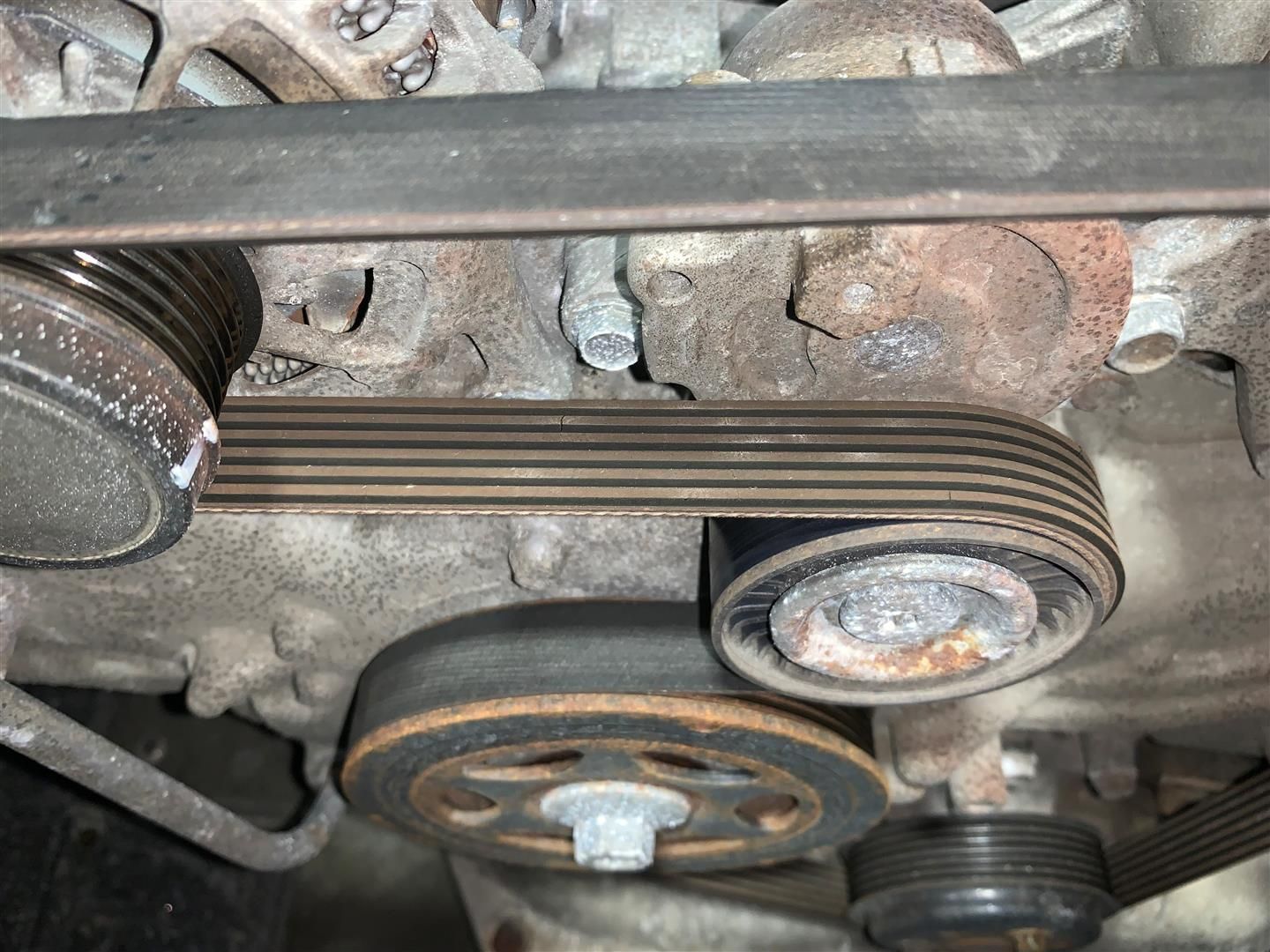 A close up of a belt on a car engine | Lou's Car Care Center Inc.