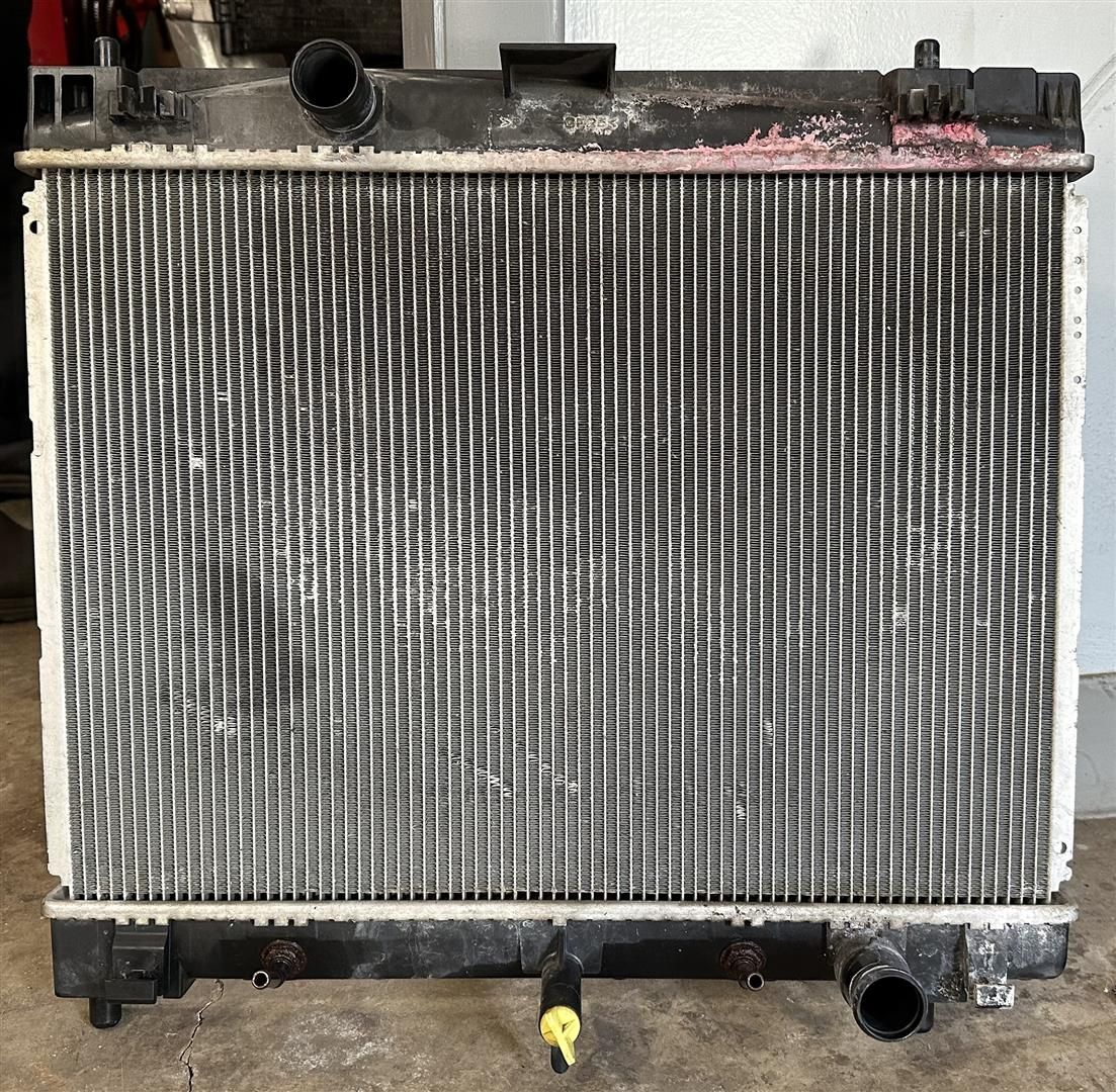 A radiator is sitting on the ground in a garage | Lou's Car Care