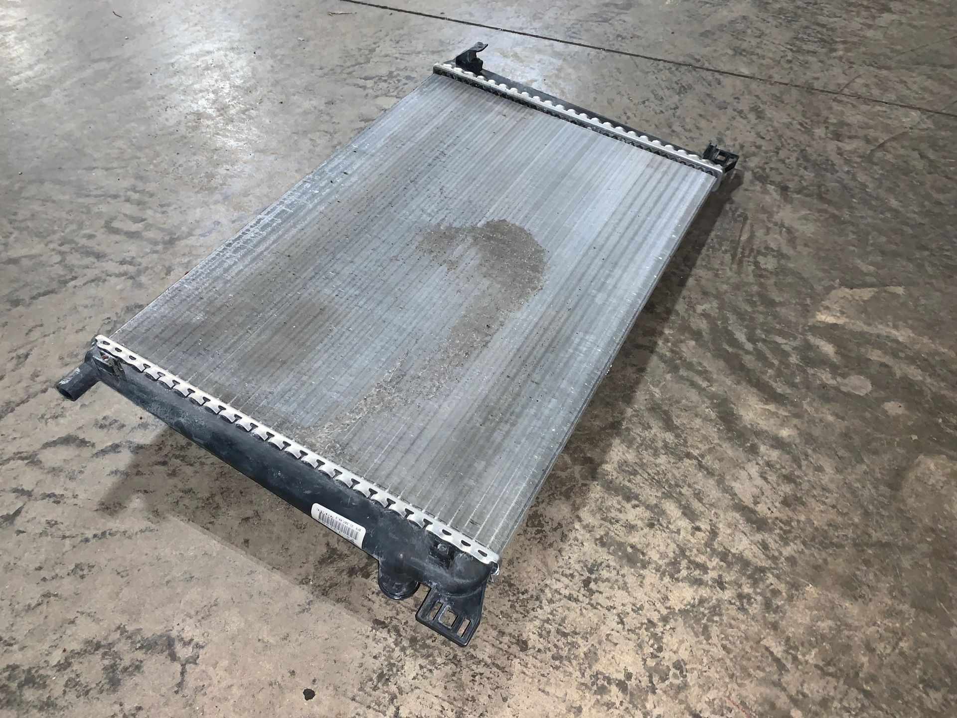 A radiator is sitting on top of a concrete floor. | Lou's Car Care Center, Inc.