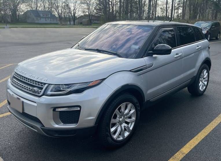 A silver range rover evoque is parked in a parking lot. | Lou's Car Care Center, Inc.