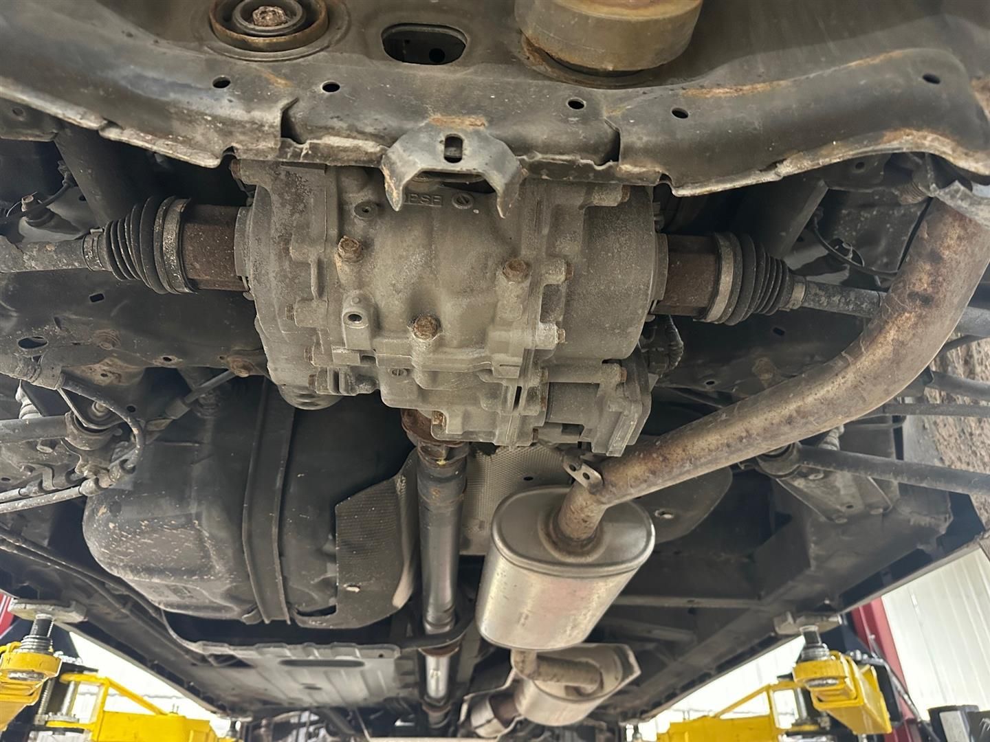 A close up of the underside of a car in a garage. | Lou's Car Care Center, Inc.