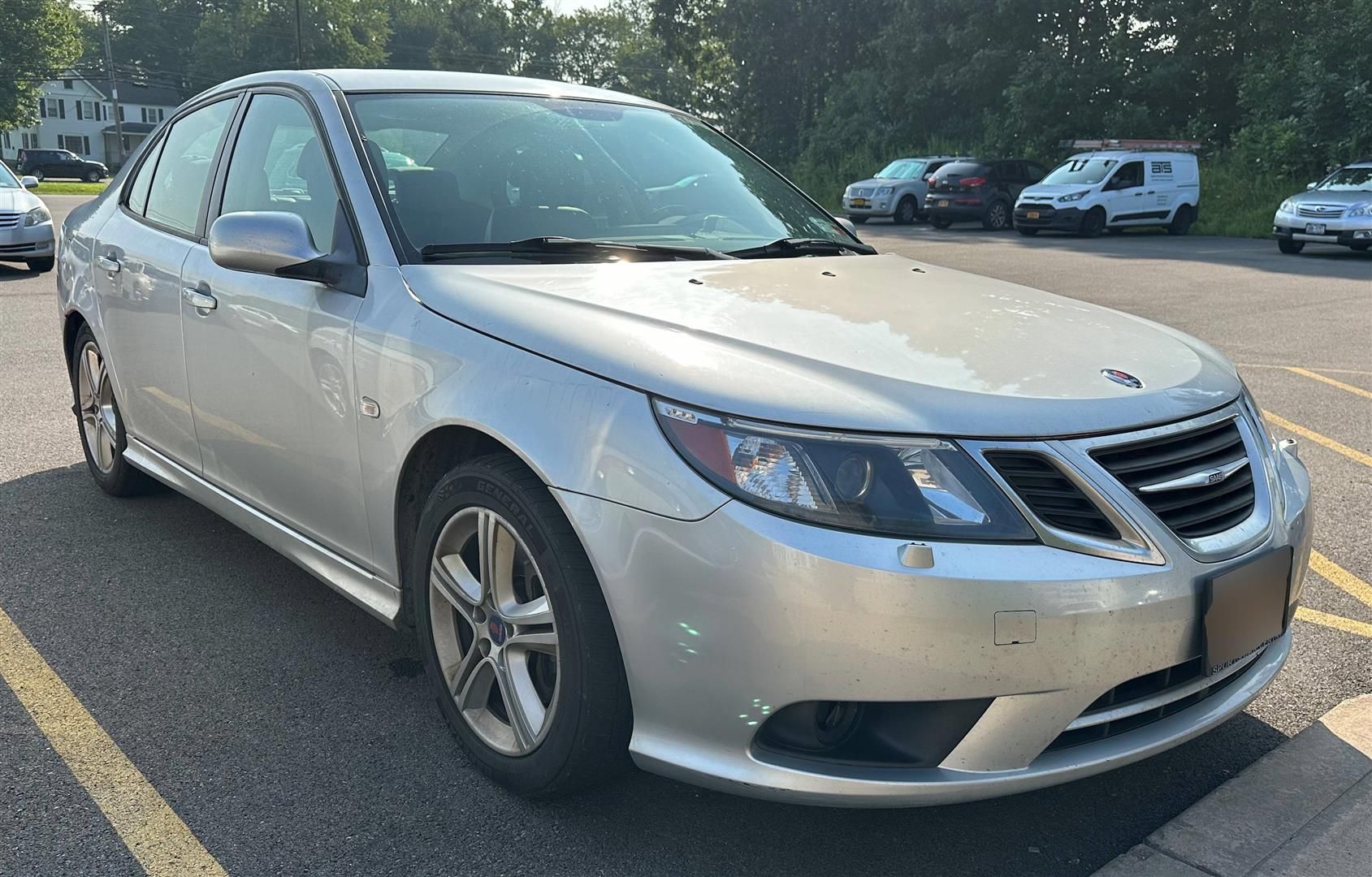 A silver car is parked in a parking lot. | Lou's Car Care Center, Inc.