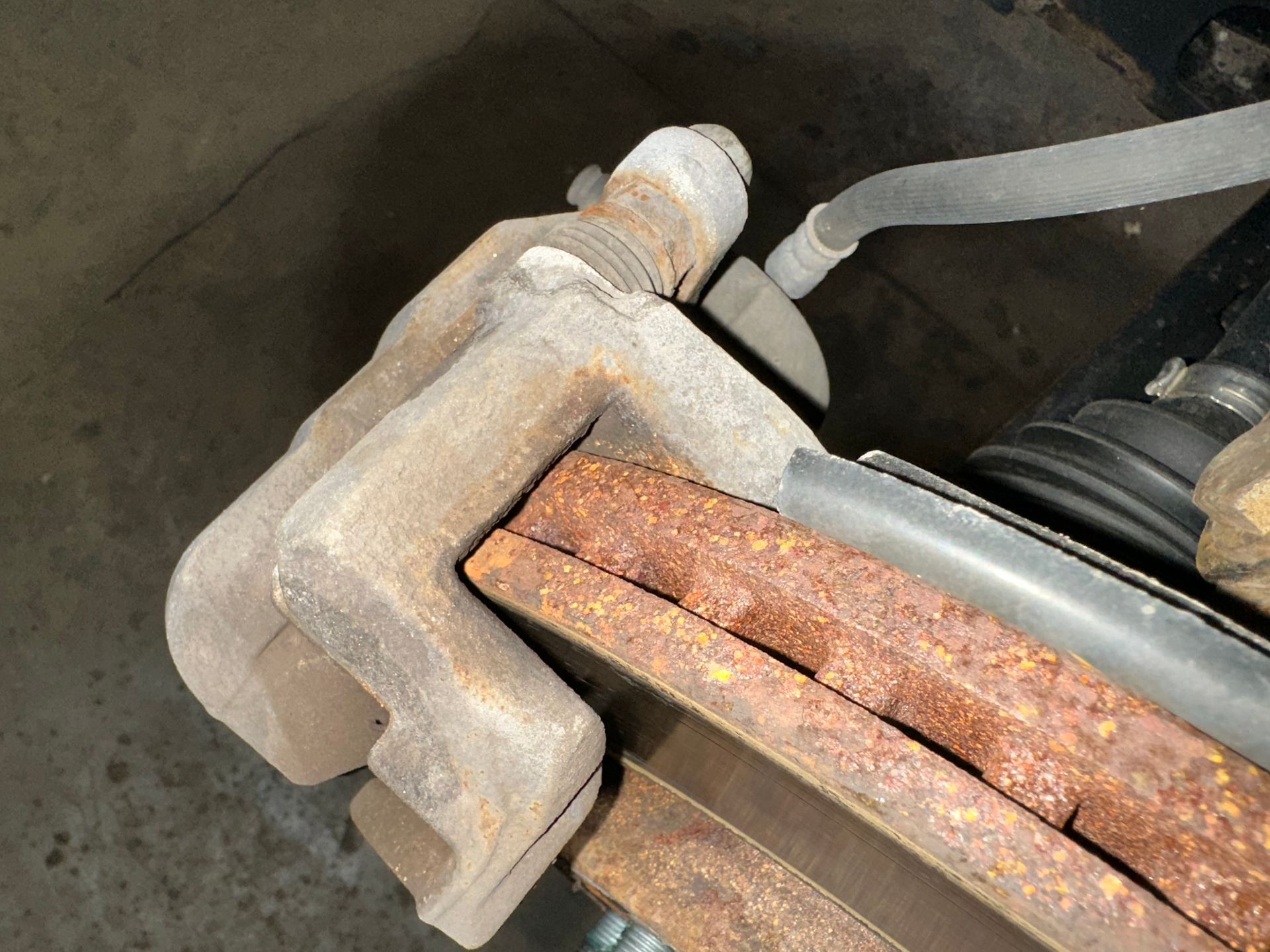 A close up of a rusty brake caliper on a car. | Lou's Car Care Center Inc.