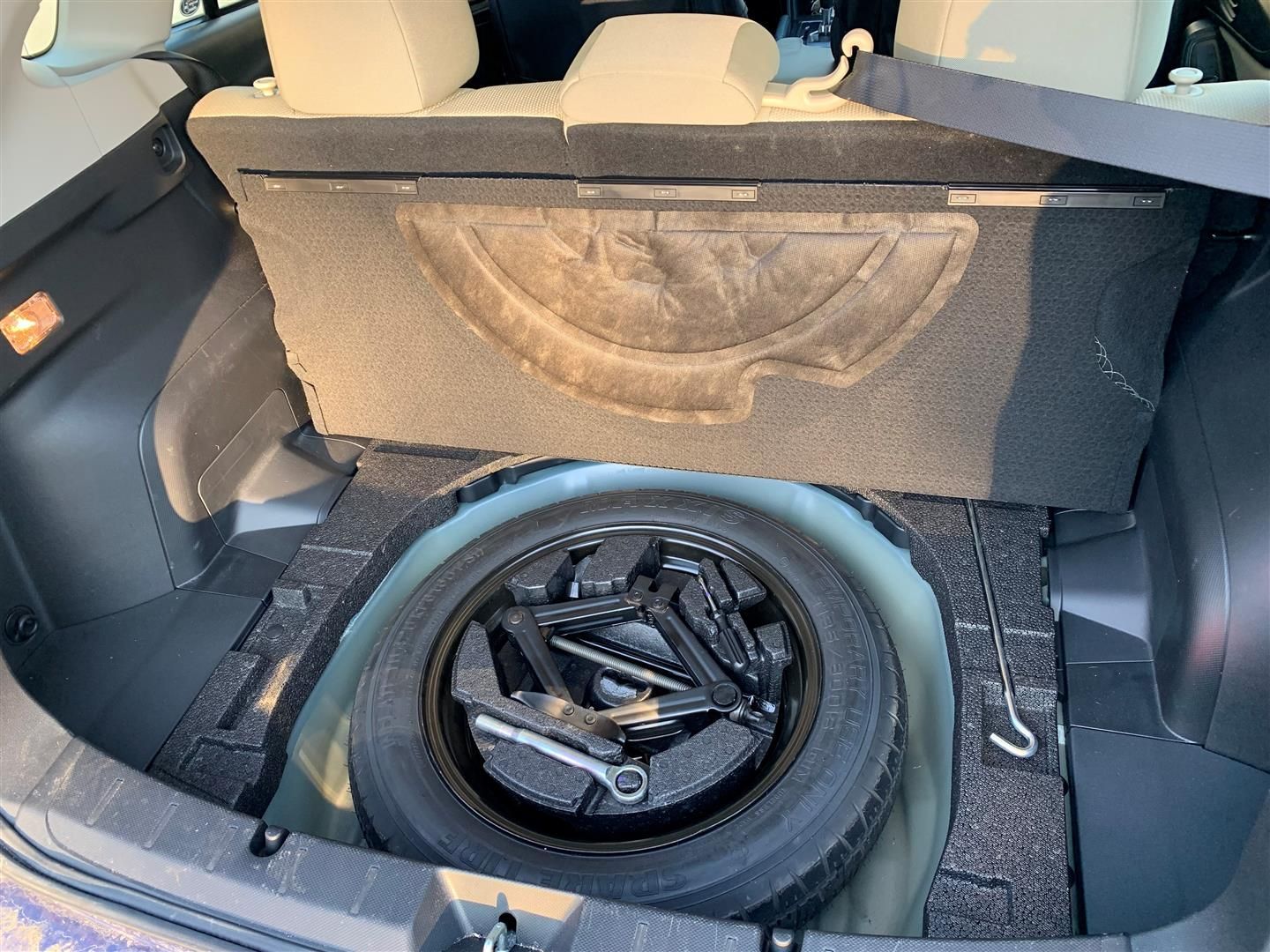 A spare tire is in the trunk of a car. | Lou's Car Care Center Inc.