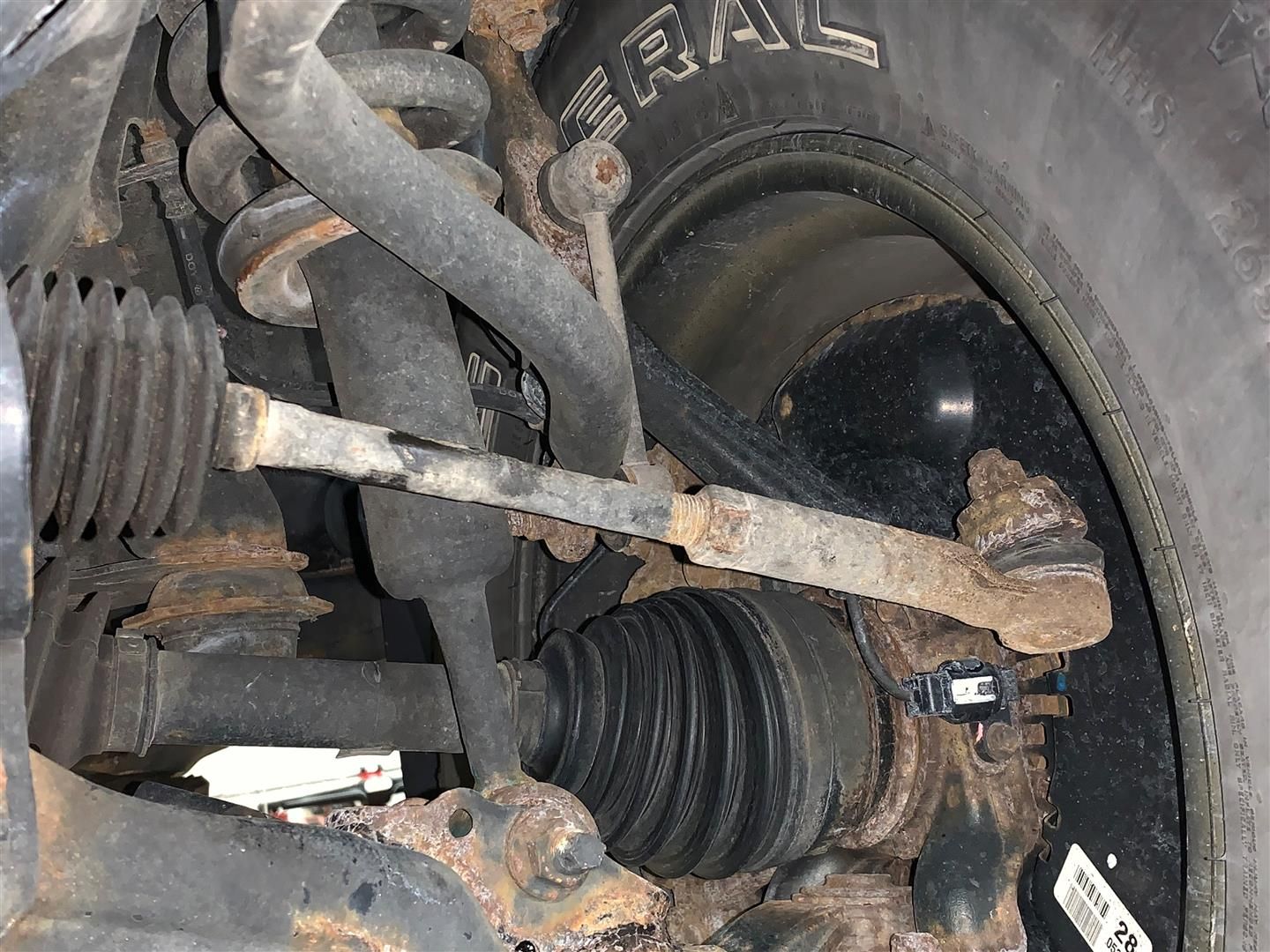 A close up of a car 's suspension and a tire. | Lou's Car Care Center Inc.