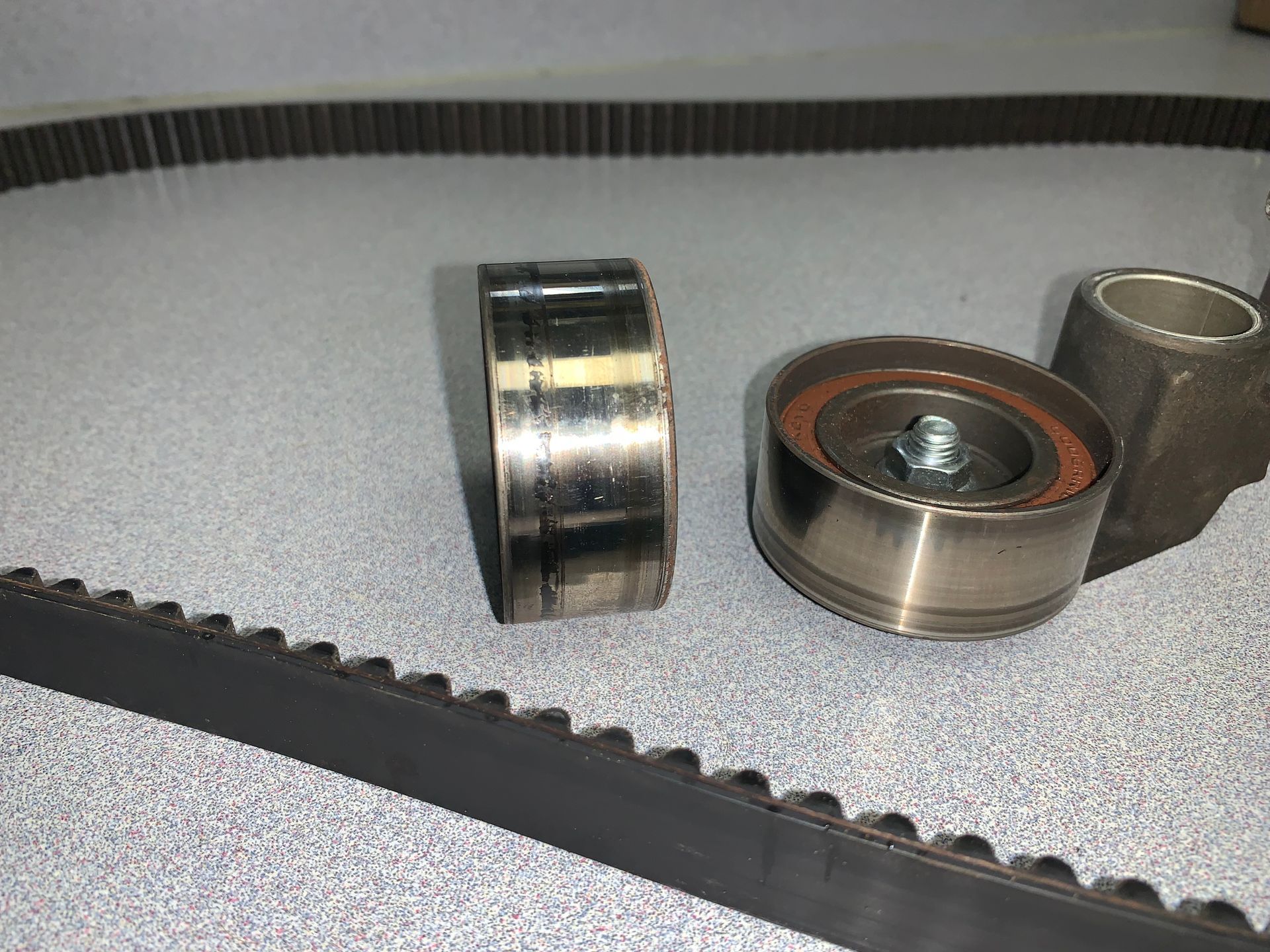 A close up of a belt and bearings on a table | Lou's Car Care Center Inc.